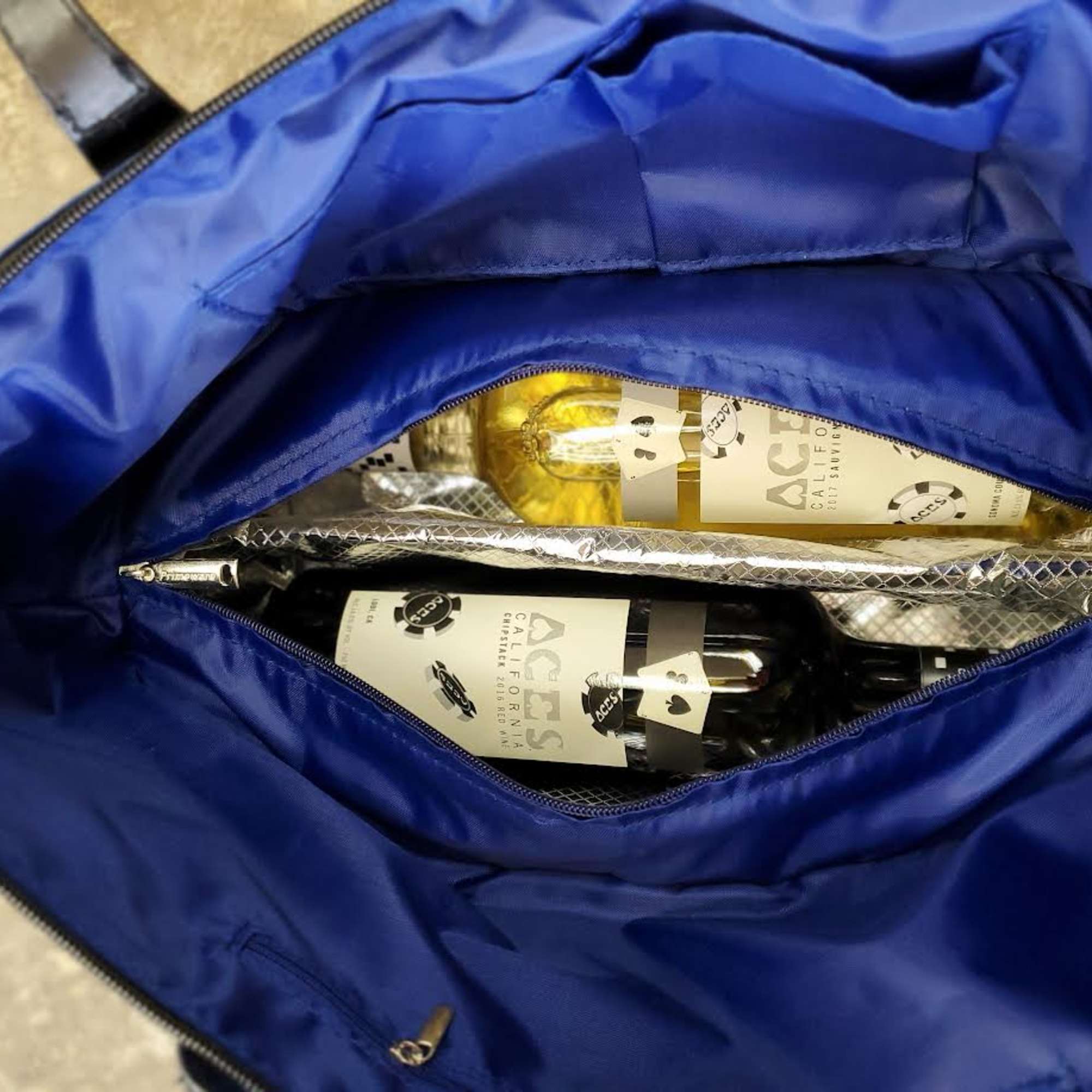 Blue bag holding two wine bottles and a wrapped item