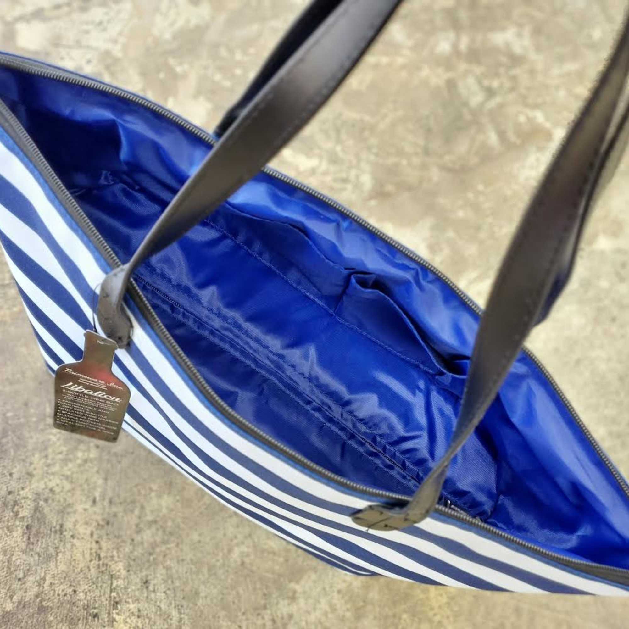 Blue-and-white striped tote bag with black handles and a zipper top