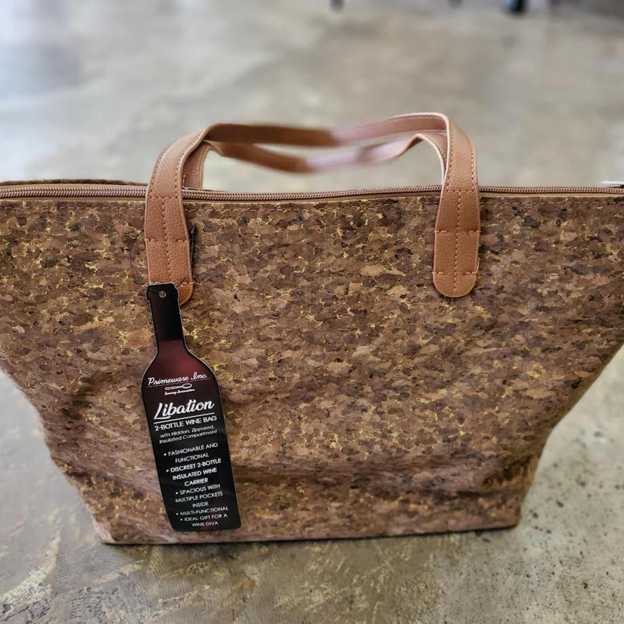 Brown cork tote bag with tan handles and a zipper closure
