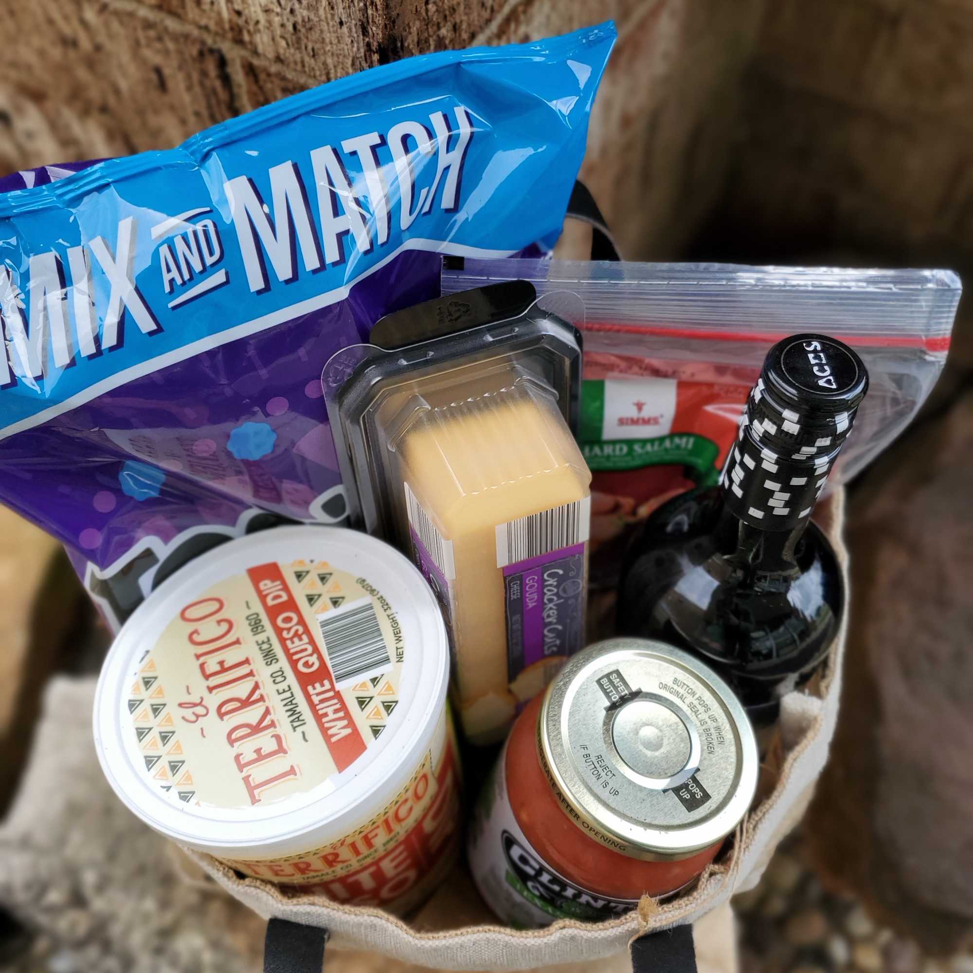 Gift basket with snacks, cheese, and a bottle of wine