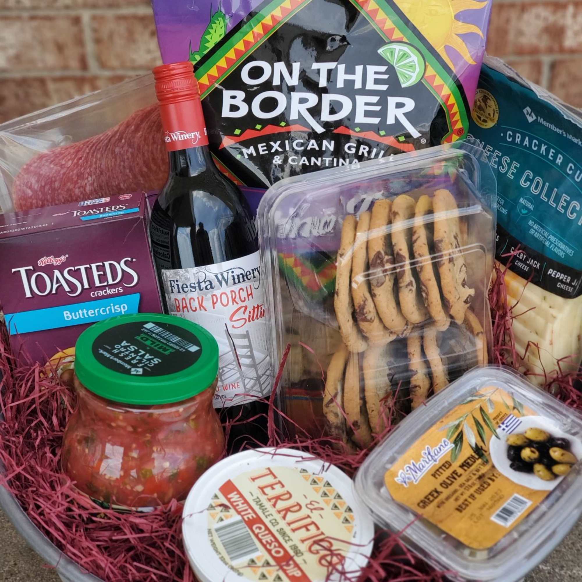 Gift basket with wine, crackers, salsa, cheese, and olives
