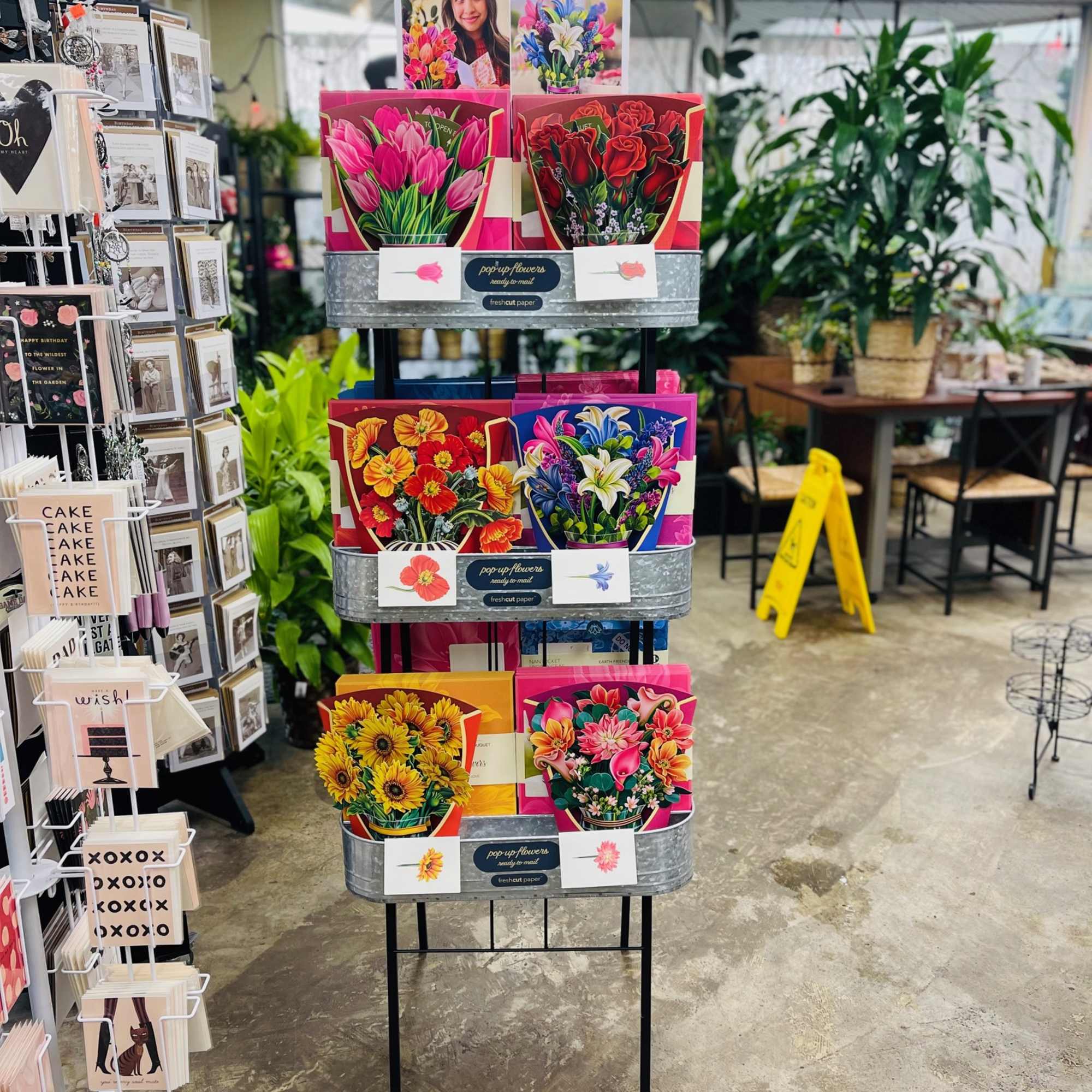 Display rack of colorful pop-up flower cards in a shop