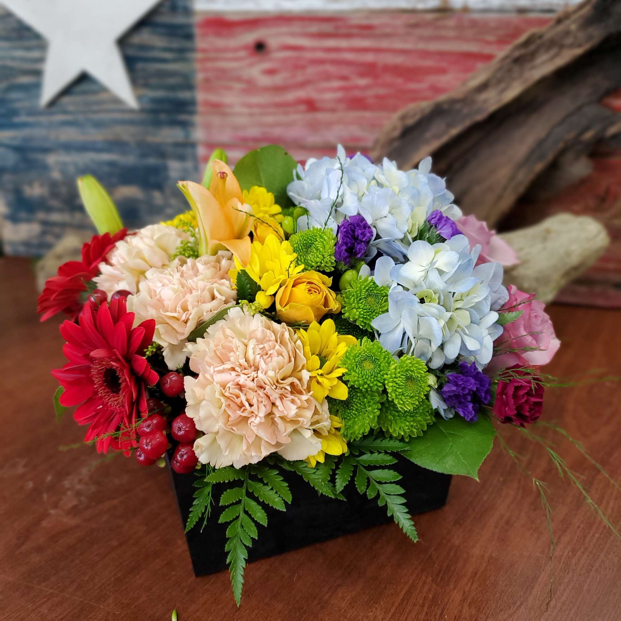 Colorful mixed flower arrangement in a black rectangular box