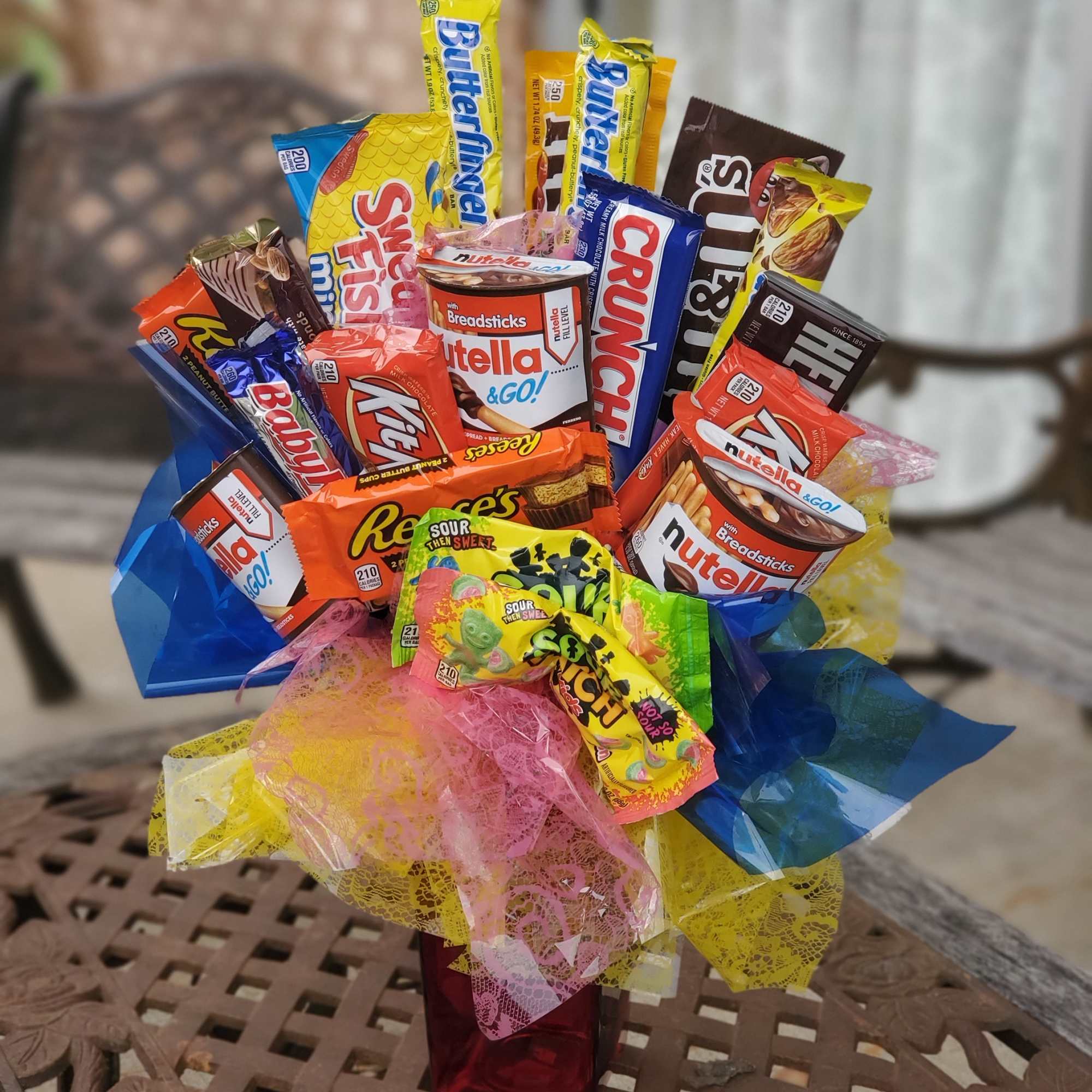 Assorted candy bars arranged in a gift bouquet with colorful mesh wrap