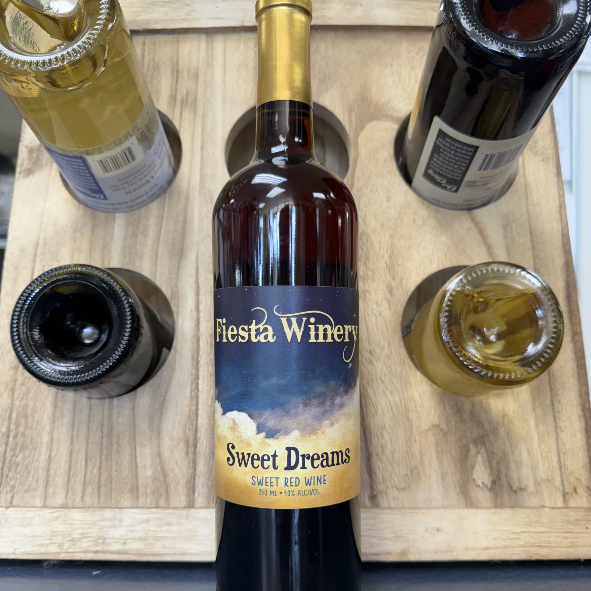 Wine bottle in a wooden carrier with four other bottles around it