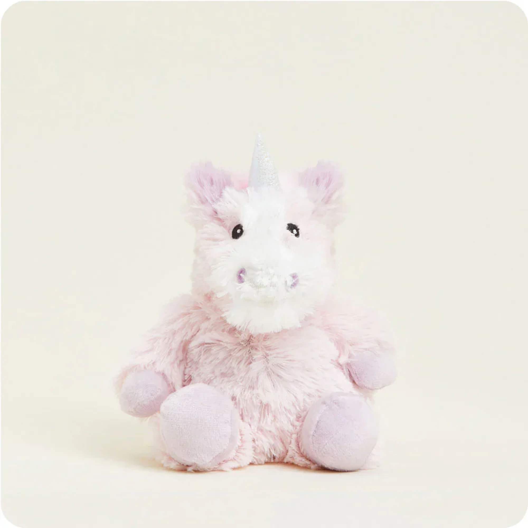 Pink plush unicorn with a silver horn sitting on a light background