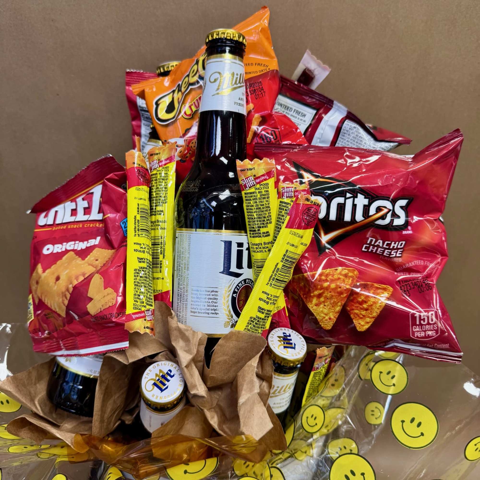 Gift bouquet of beer bottles and snack bags wrapped in smiley-face cellophane