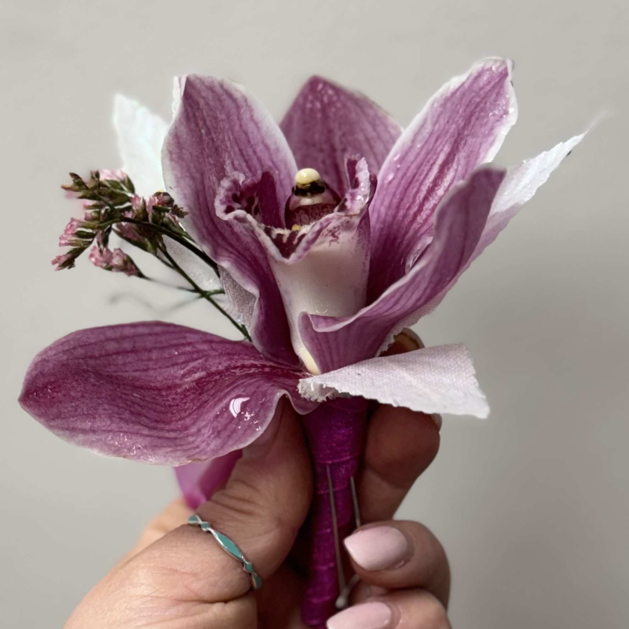 Purple orchid corsage held in a hand