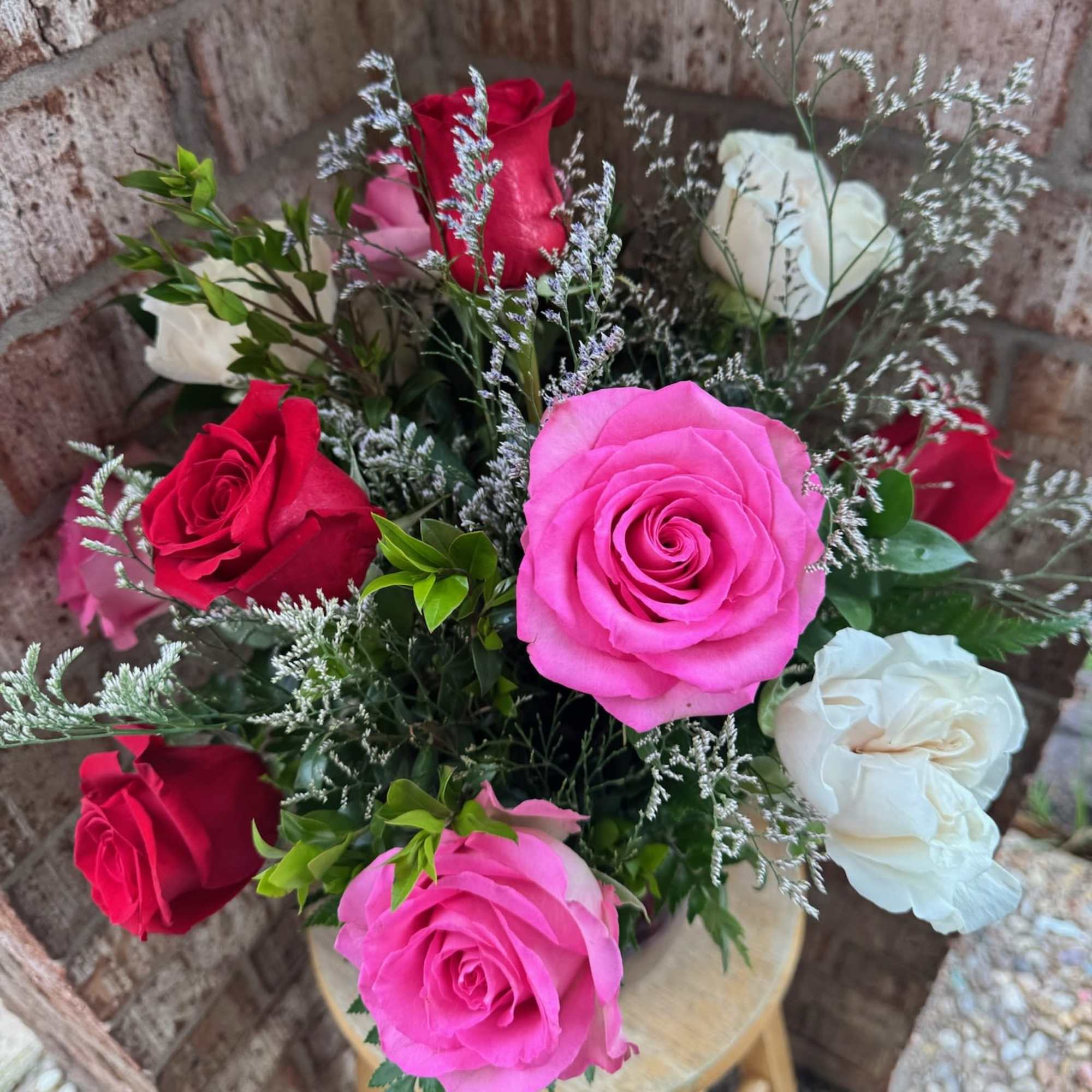 Bouquet of red, pink, and white roses with airy filler flowers