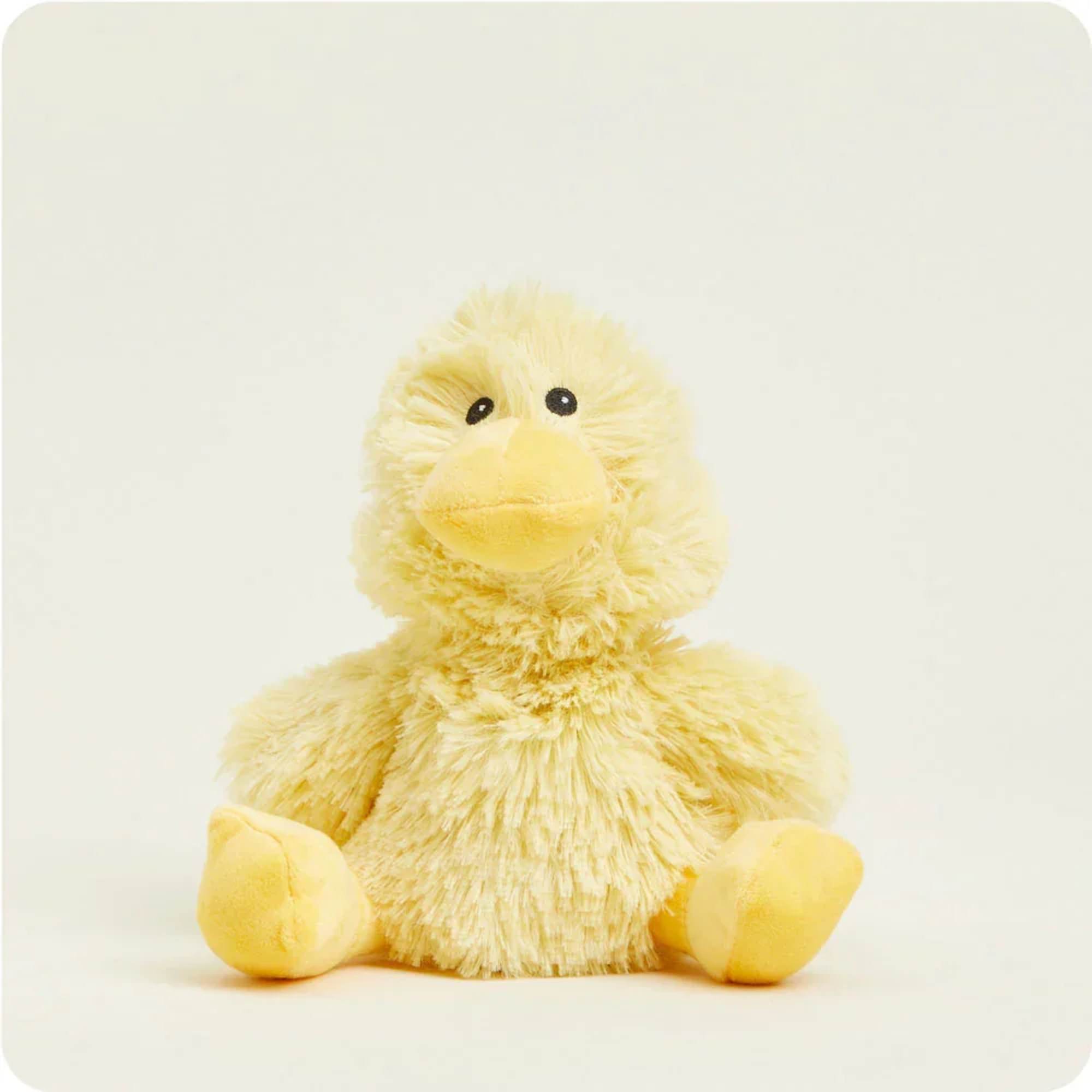 Yellow plush duck toy sitting against a plain background