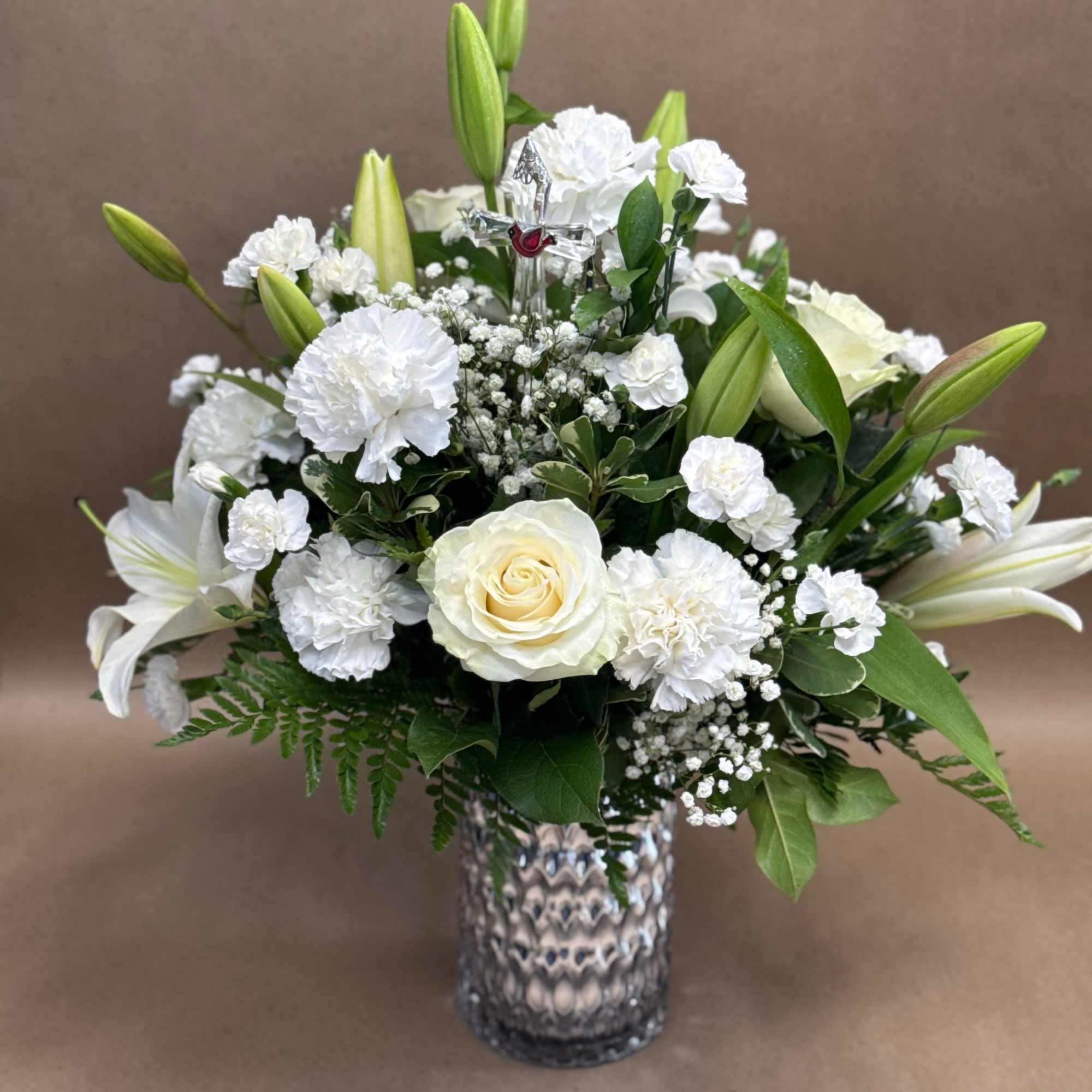 White roses and lilies arranged in a glass vase