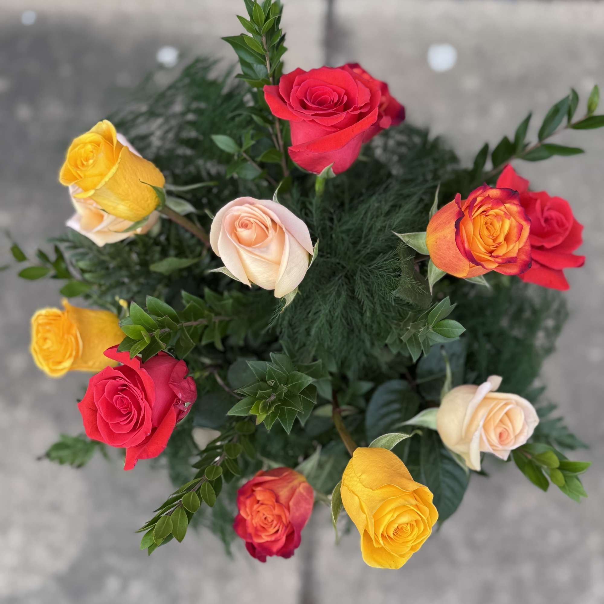 Bouquet of multicolored roses with greenery