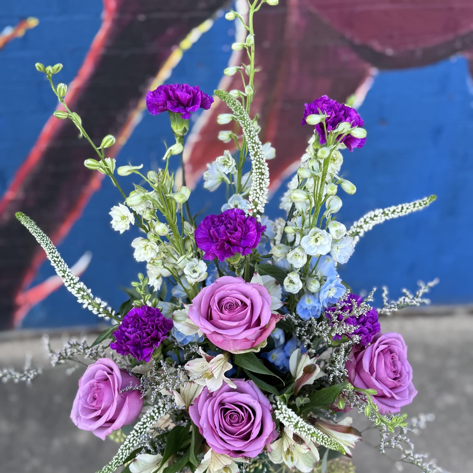 Bouquet of lavender roses, purple carnations, and white filler flowers