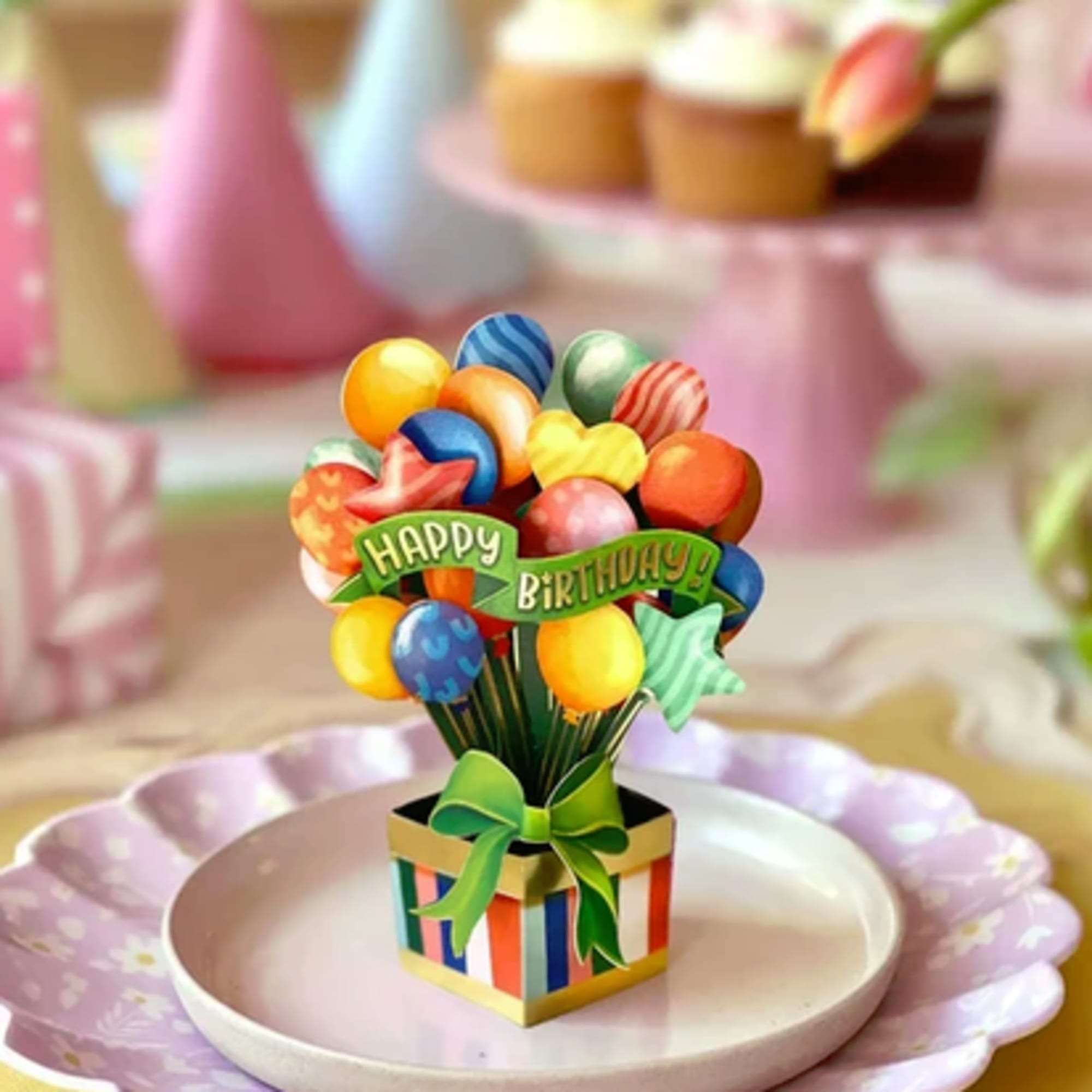 Colorful birthday balloon bouquet in a striped gift box