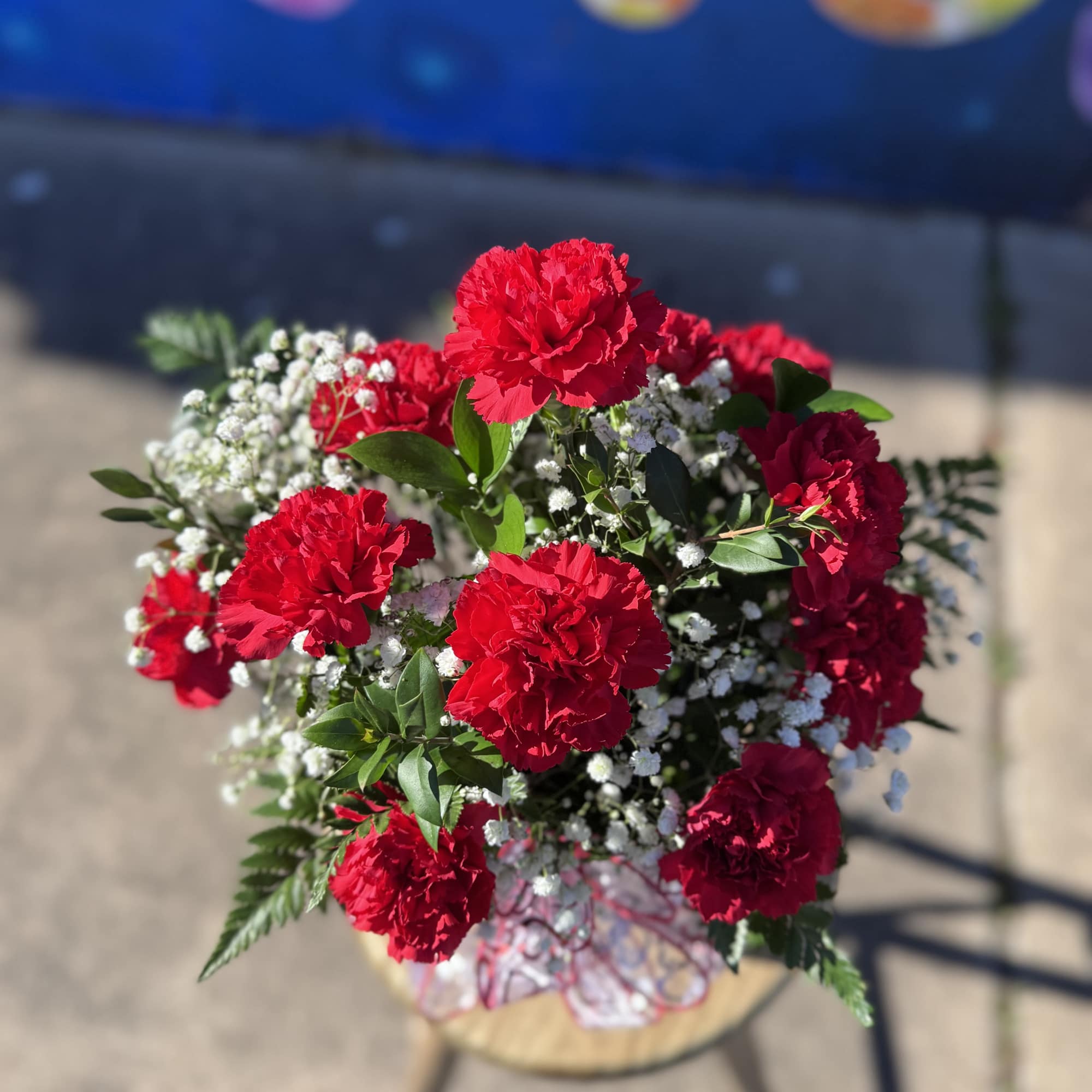 Bouquet of red carnations with baby's breath in a wrapped container