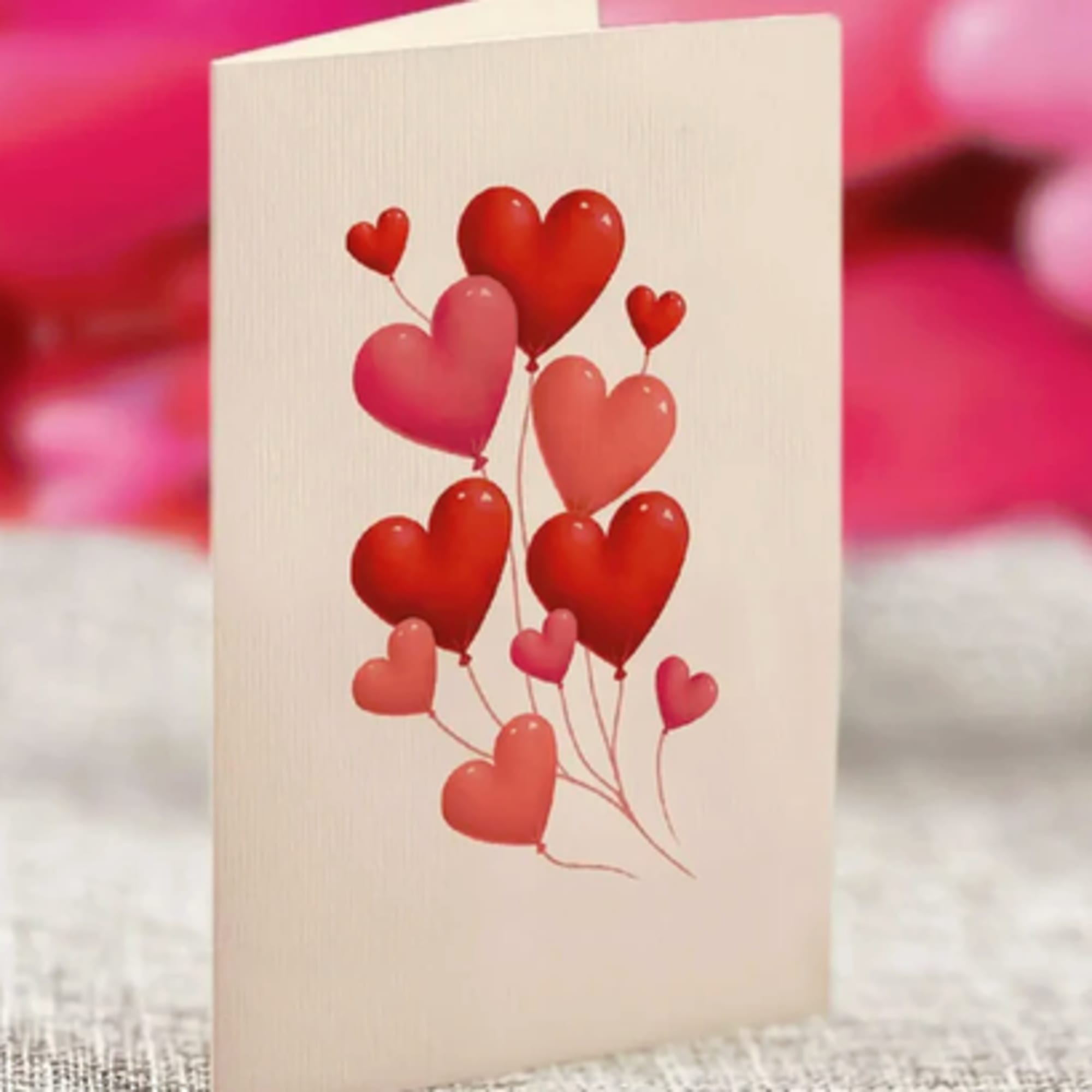 Greeting card with red and pink heart balloons