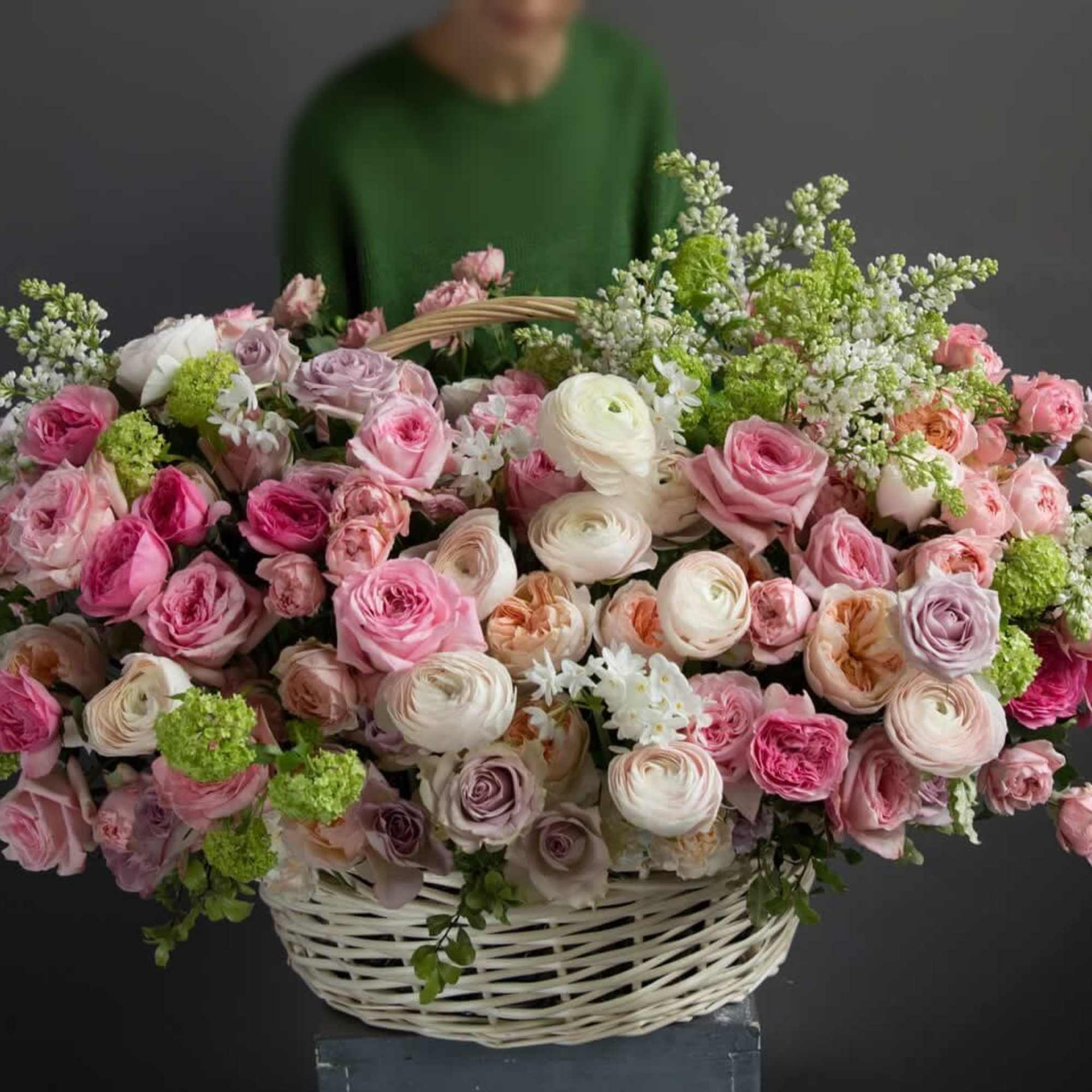 Large basket of pink and white roses with green filler flowers