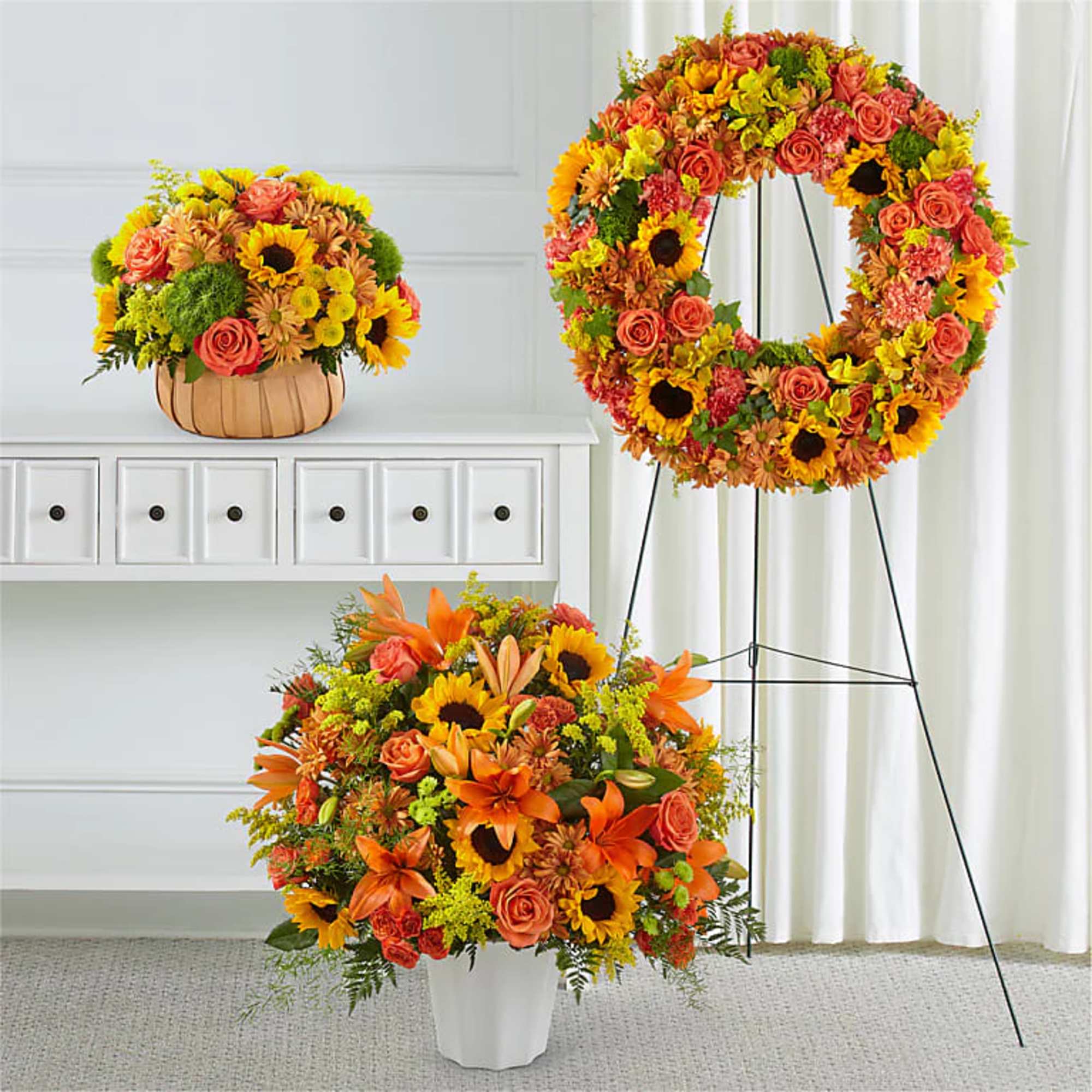 Three autumn floral arrangements with sunflowers, roses, and lilies in warm orange and yellow tones