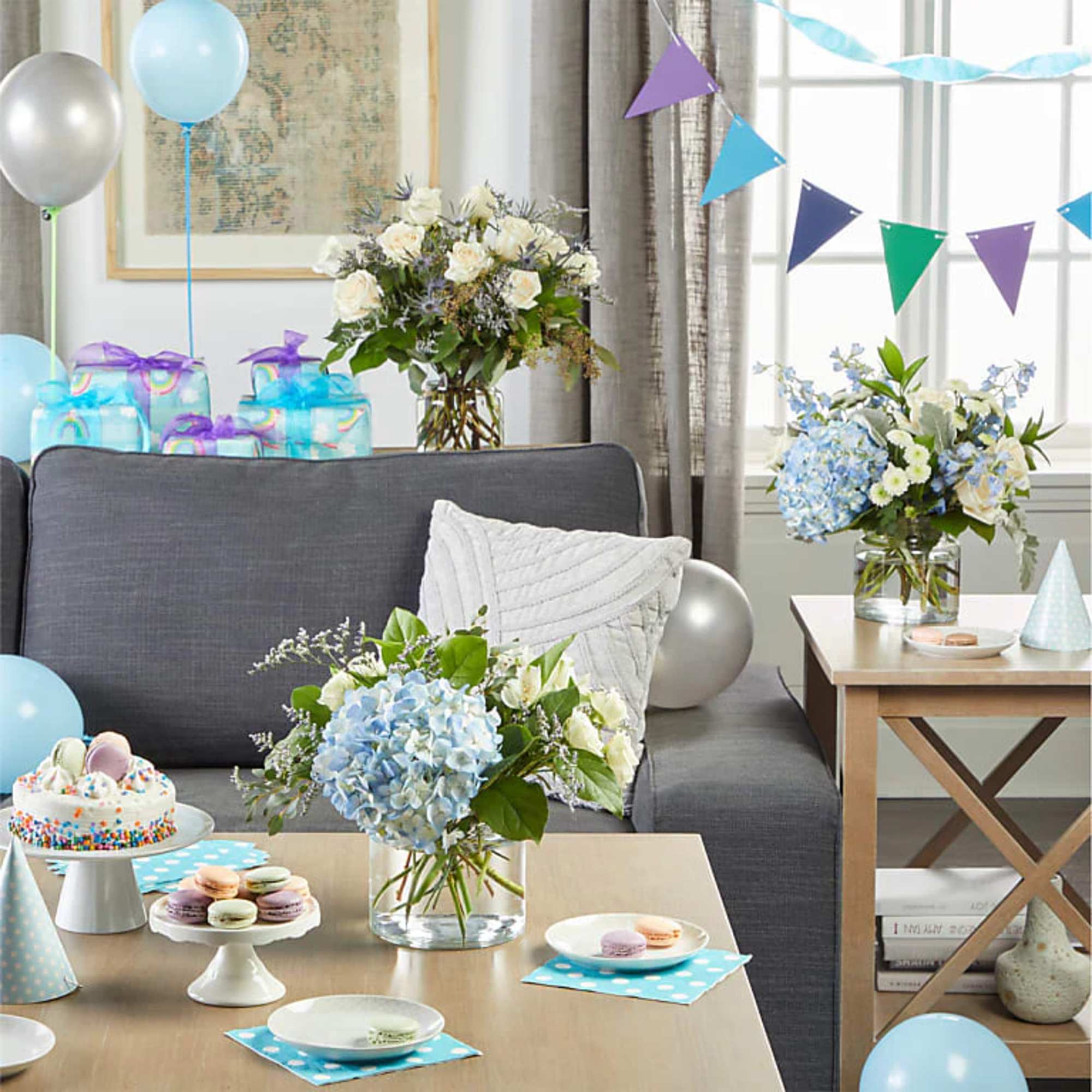Blue and white floral arrangements on tables in a party-decorated living room