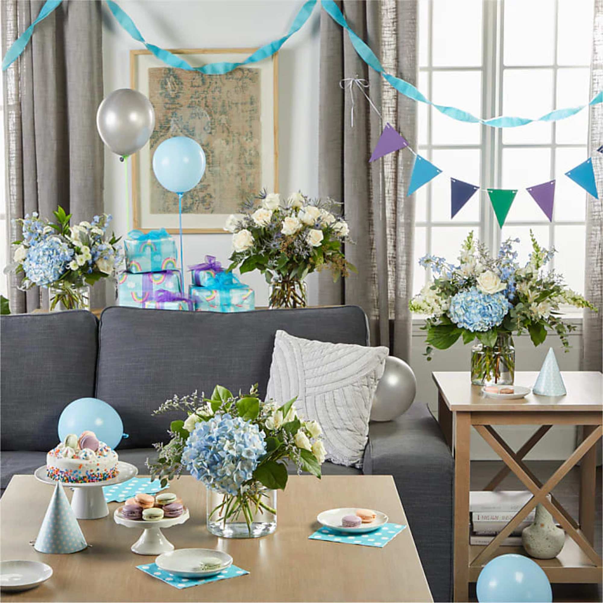 Blue and white floral arrangements on tables in a decorated party room