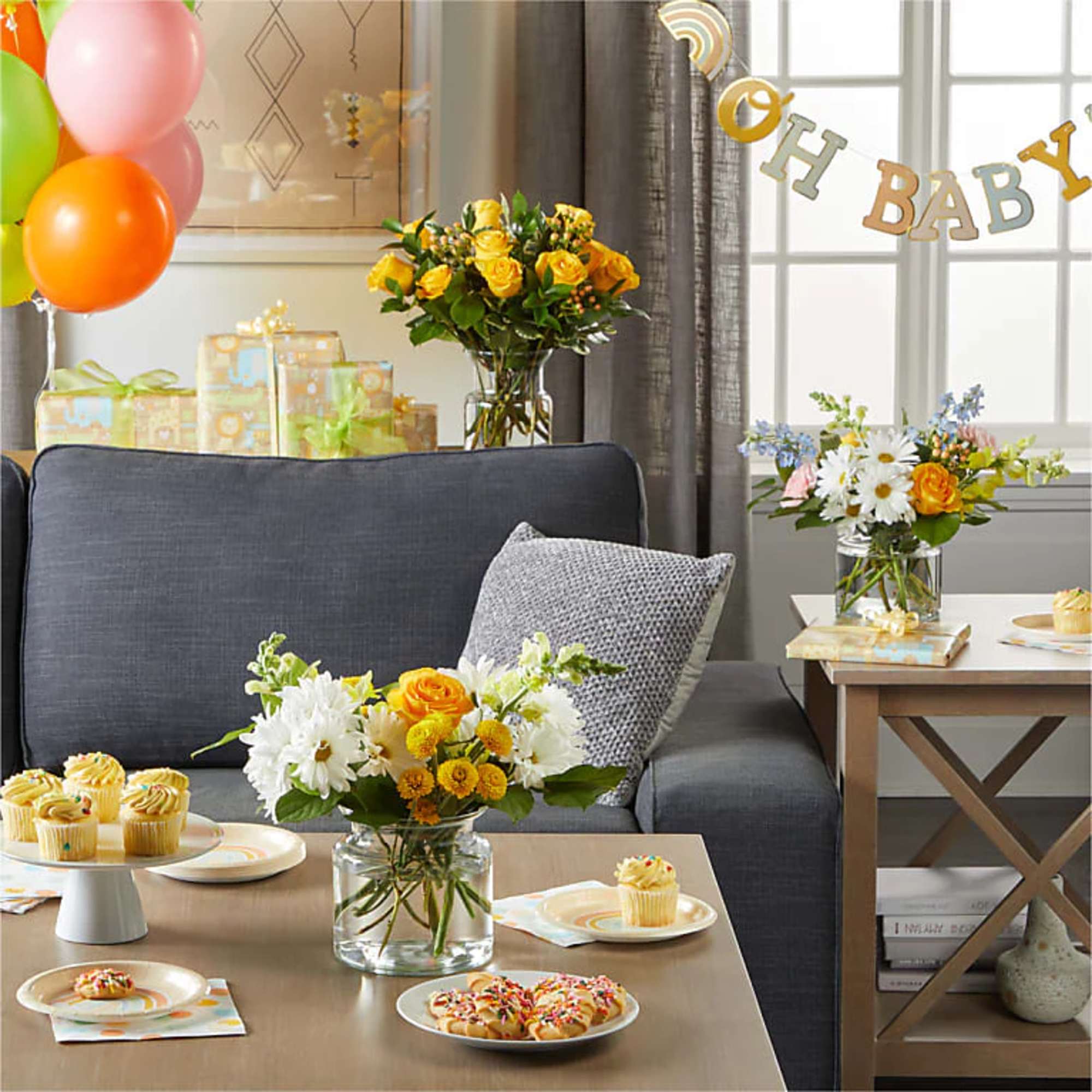 Flower arrangements on tables with balloons and baby shower decorations