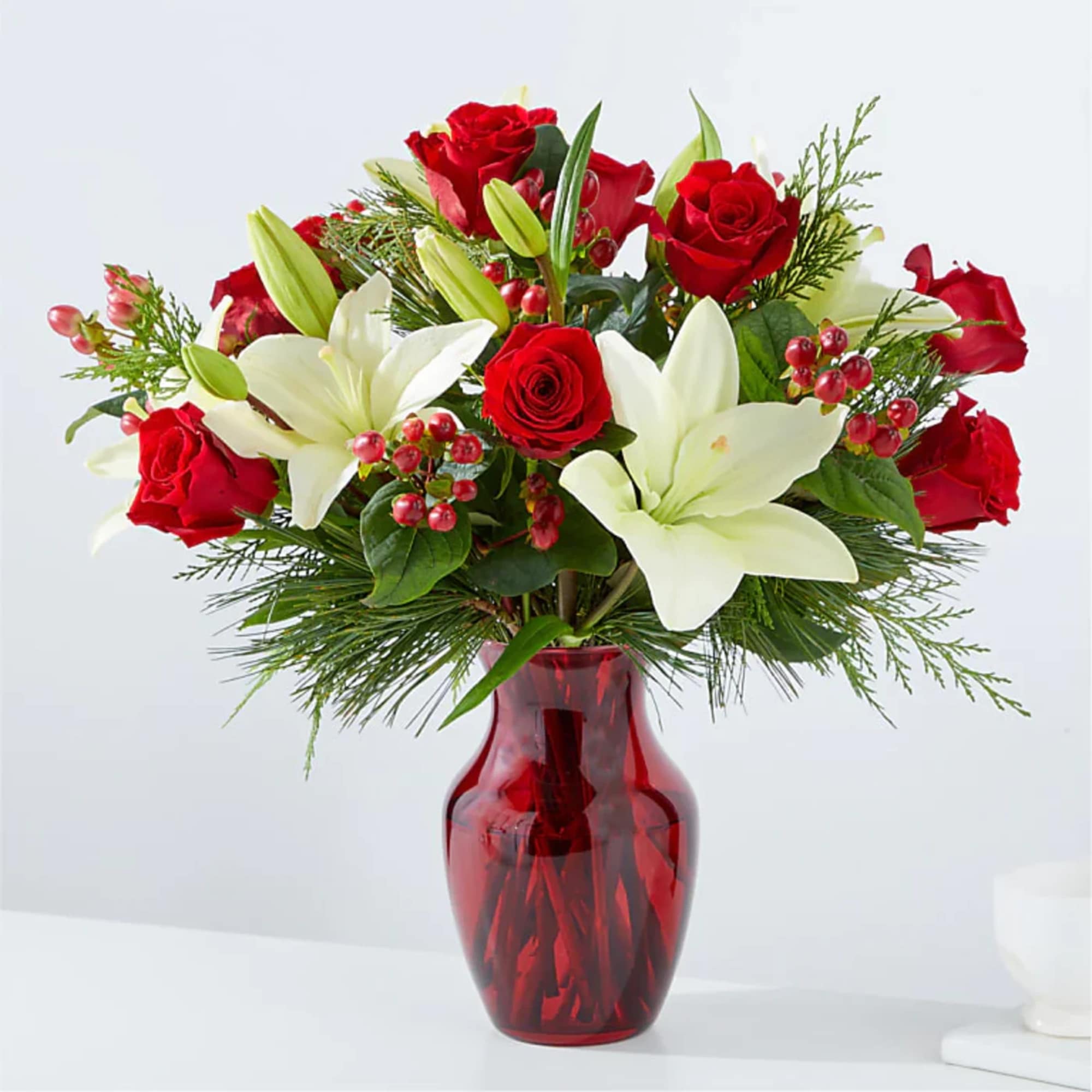 Red roses and white lilies in a red glass vase