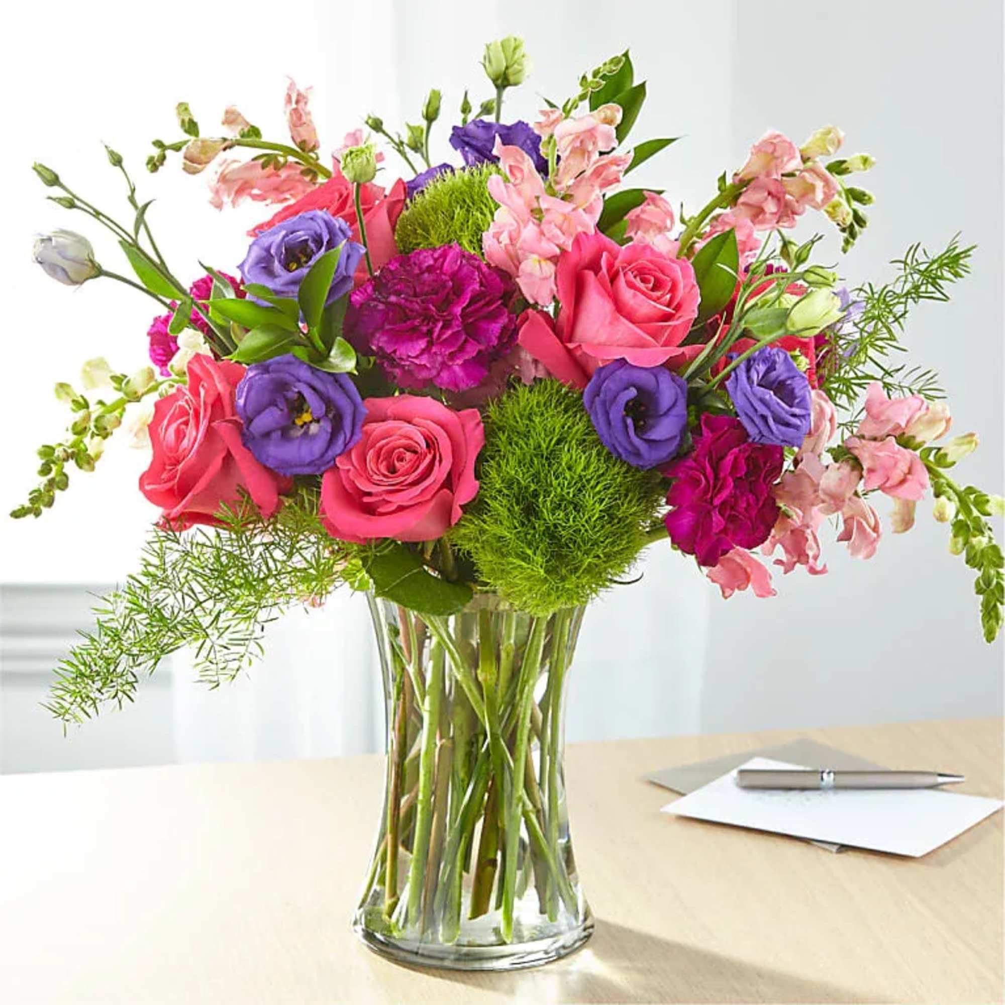 Bouquet of pink and purple flowers in a clear glass vase