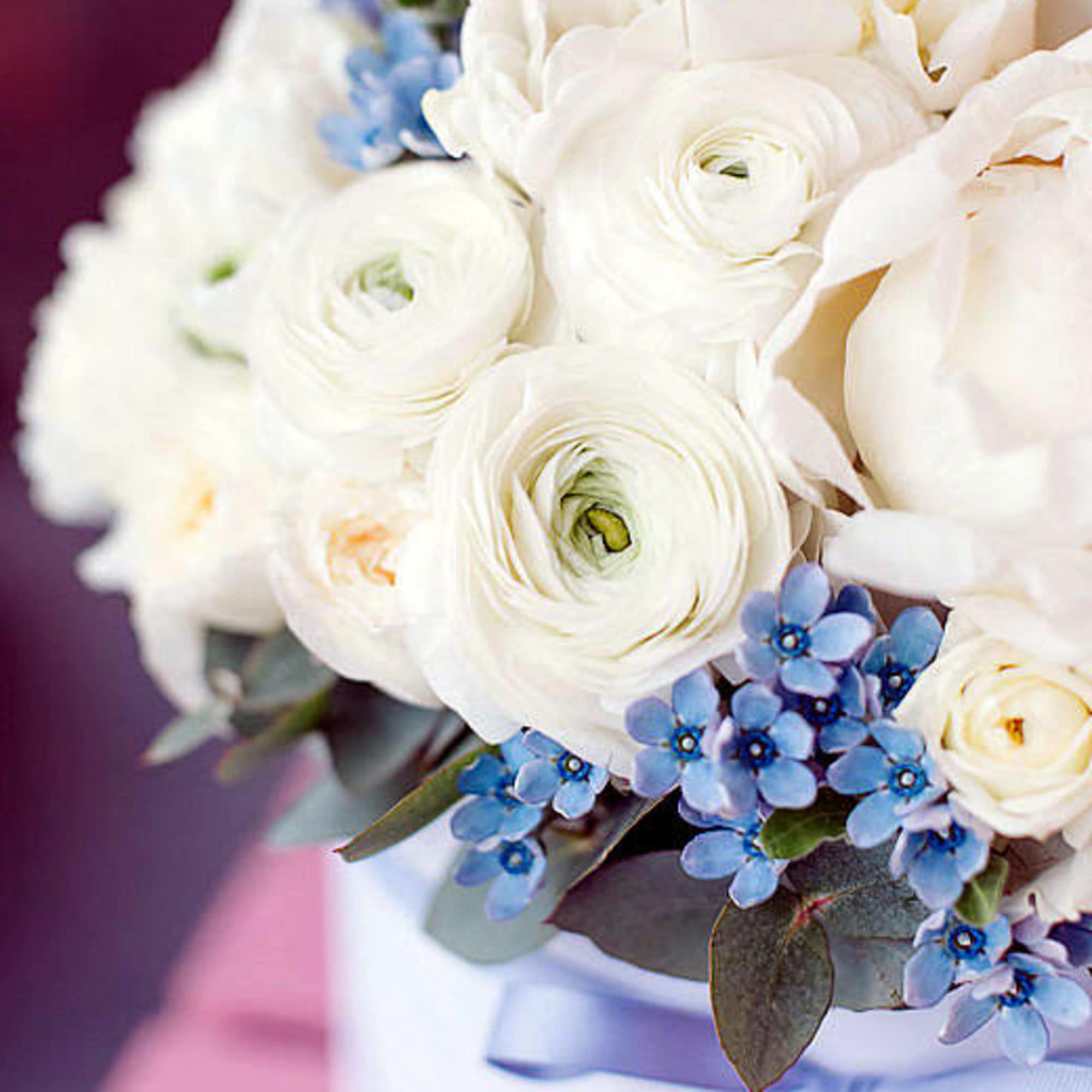 White ranunculus bouquet with small blue flowers