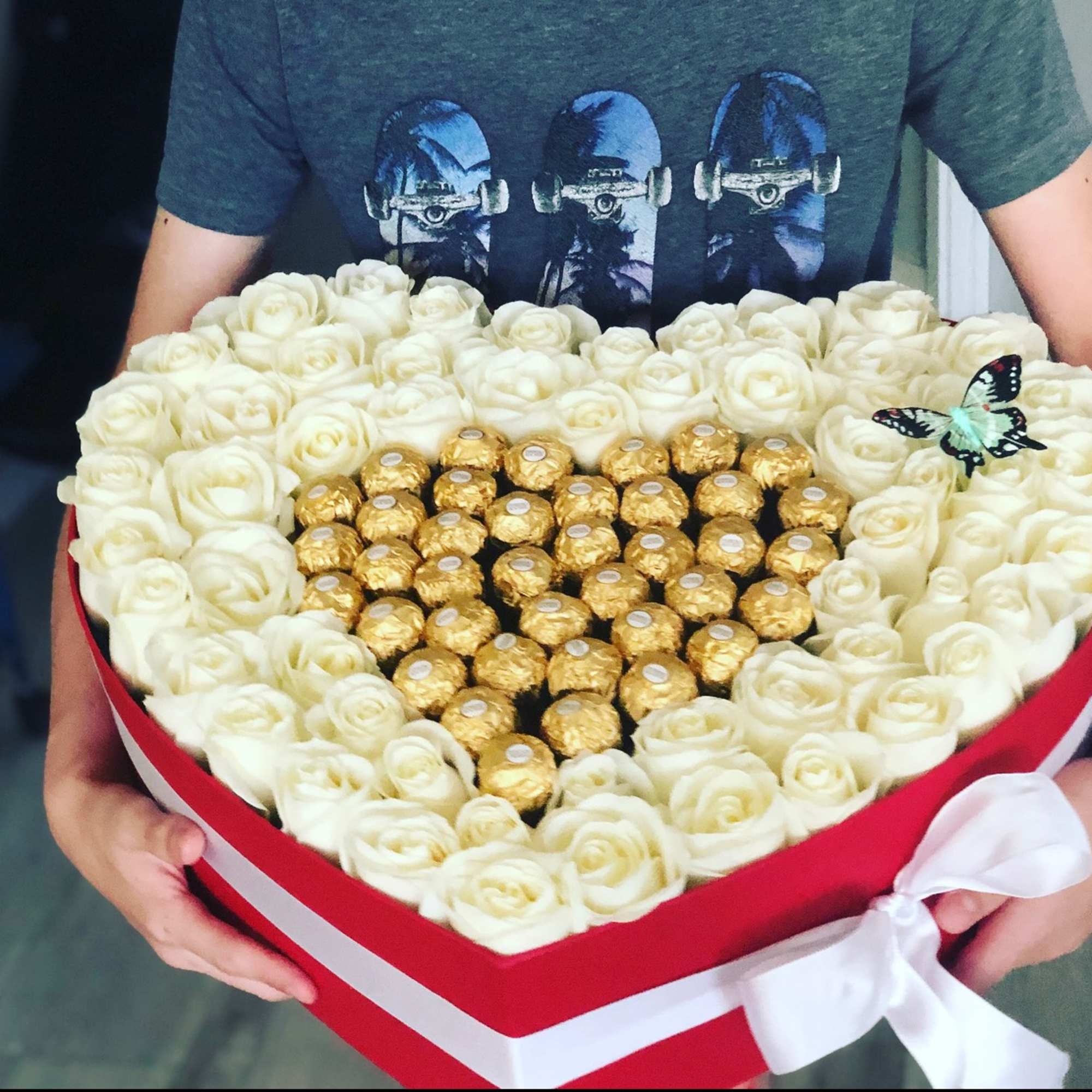 Heart-shaped box of white roses with gold-wrapped chocolates in the center