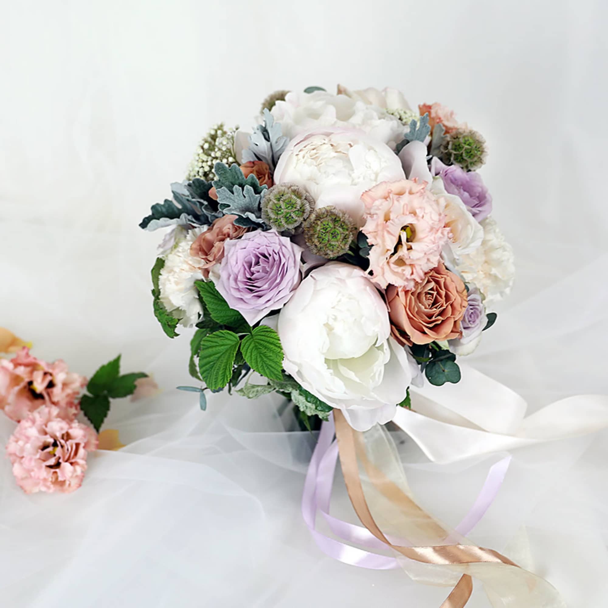 Pastel bouquet of roses and peonies with ribbon tails
