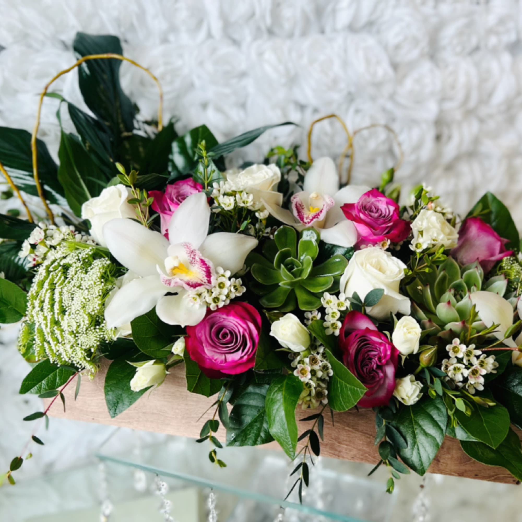 Mixed bouquet of white orchids and pink roses in a wooden box