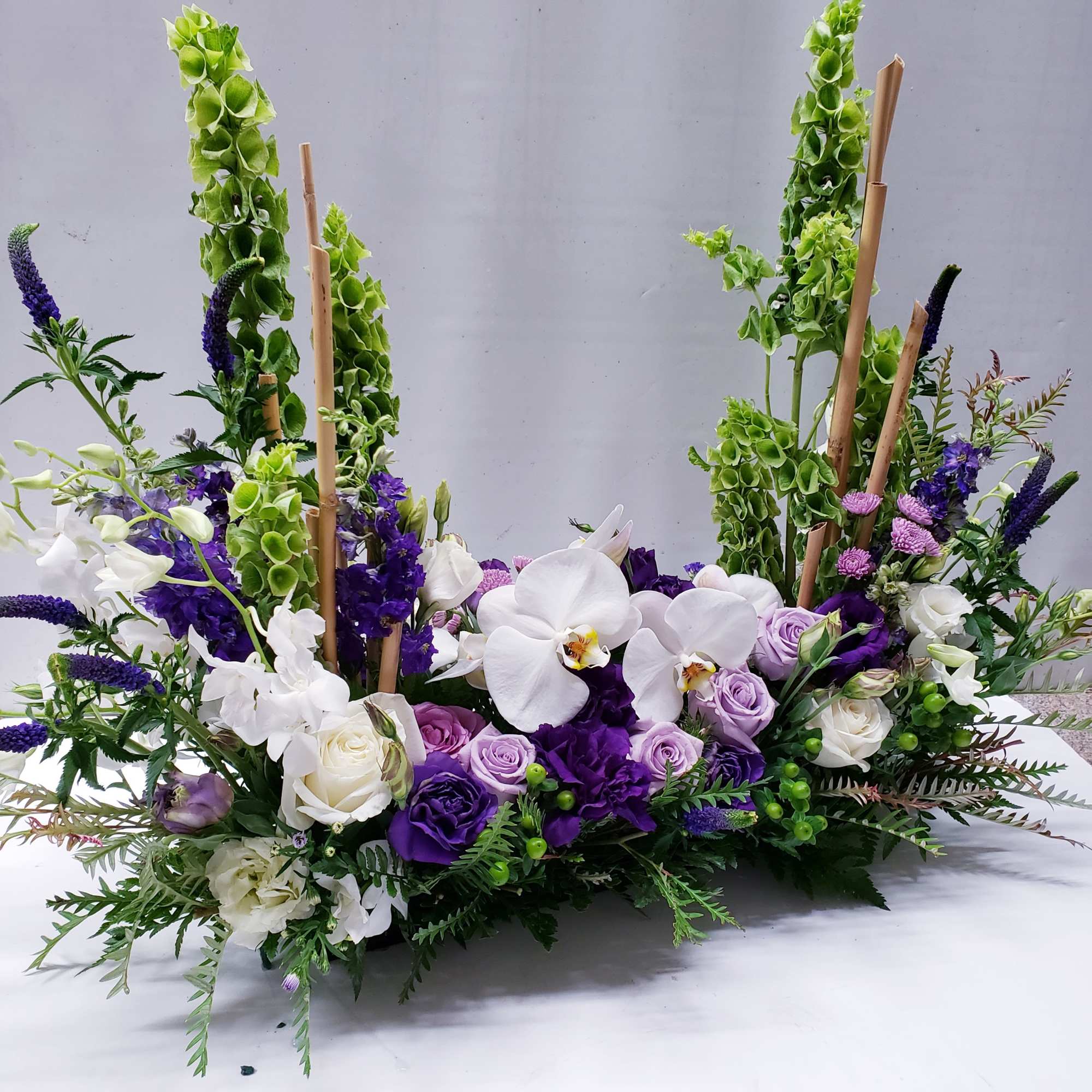 Purple and white floral arrangement with orchids and roses