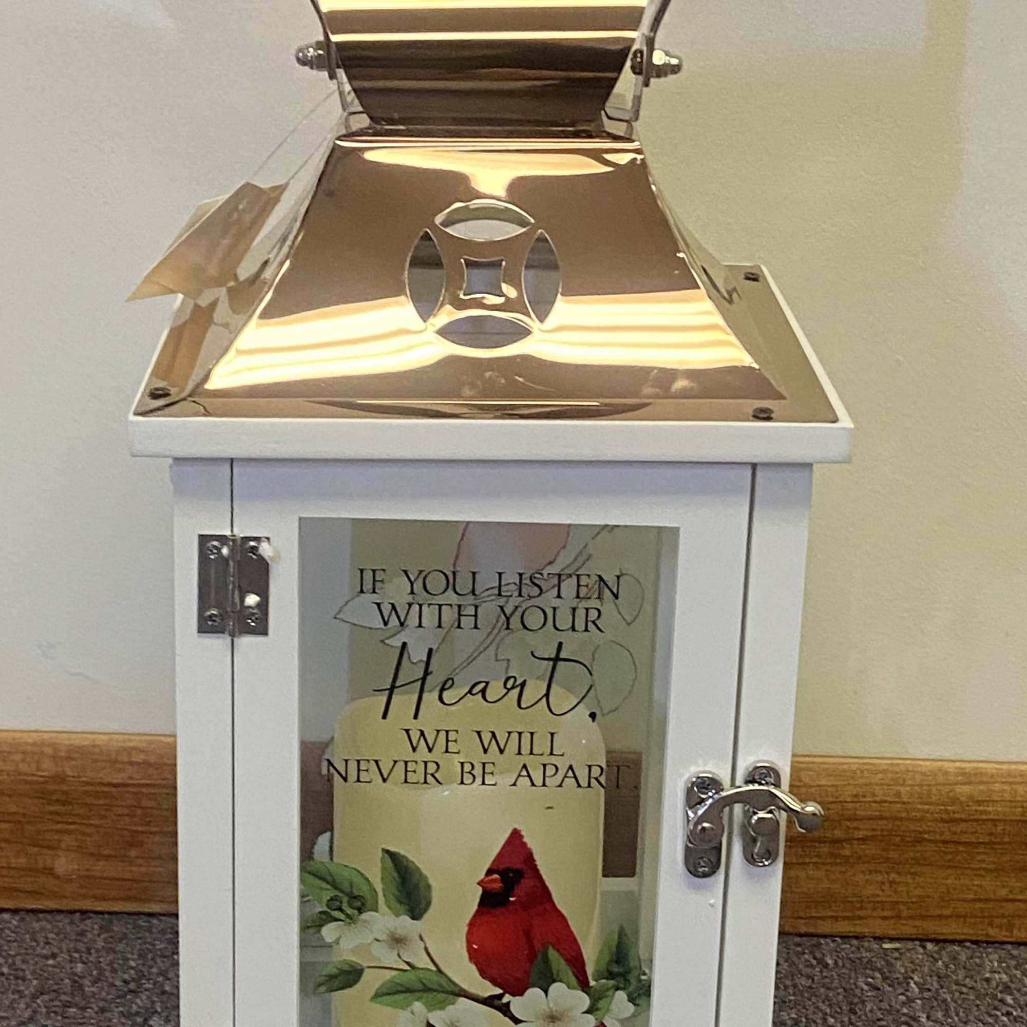 White lantern with a cardinal and floral print on the door