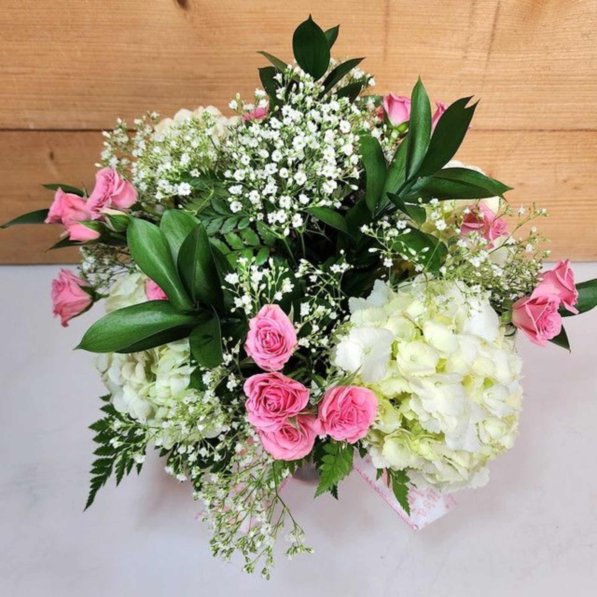 Pink roses and white hydrangeas arranged with baby's breath
