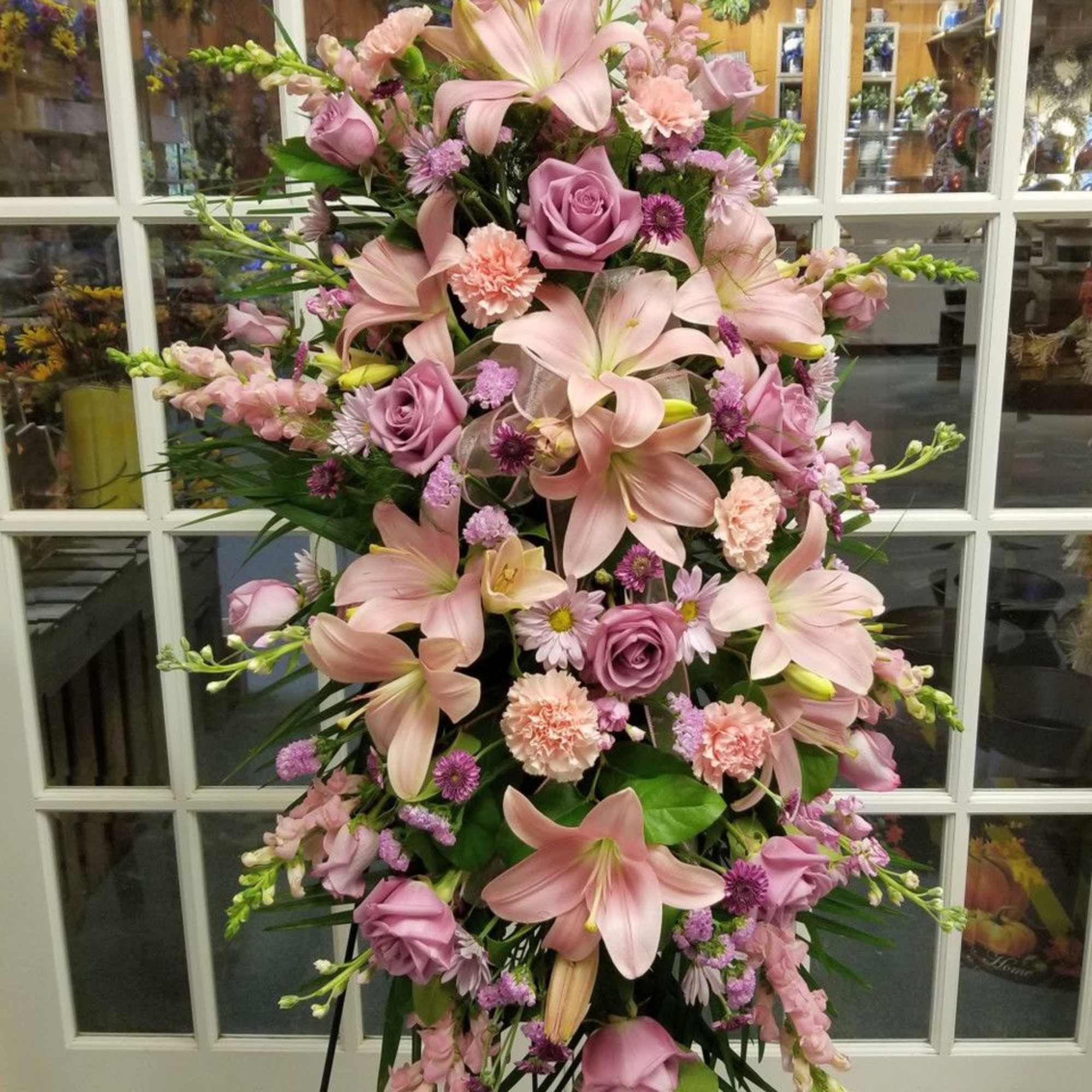 Tall pink floral standing spray with lilies, roses, and carnations