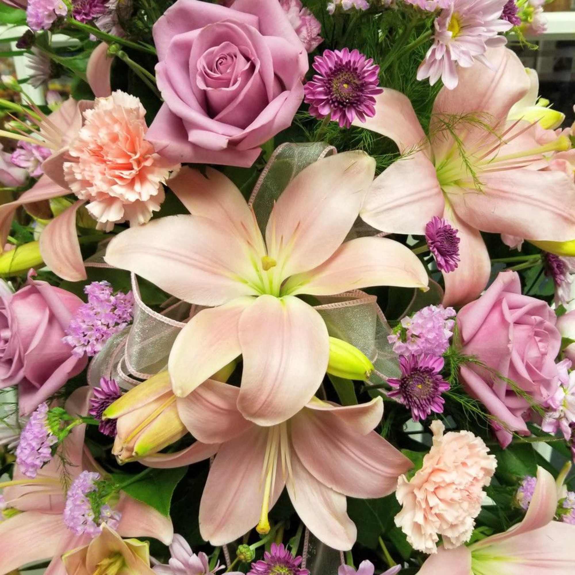 Bouquet of pink lilies, roses, and small purple flowers