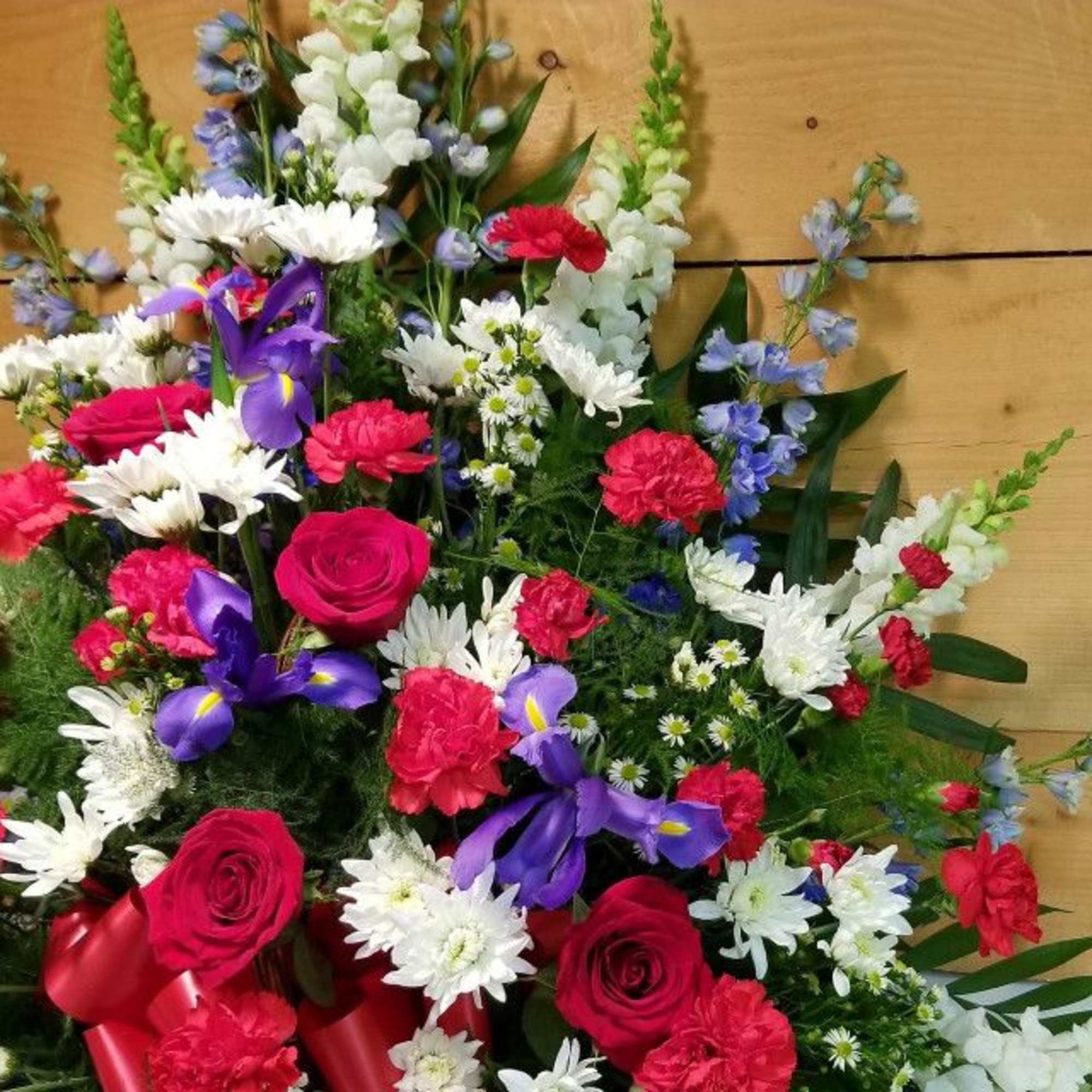 Mixed bouquet with red roses, purple irises, and white daisies