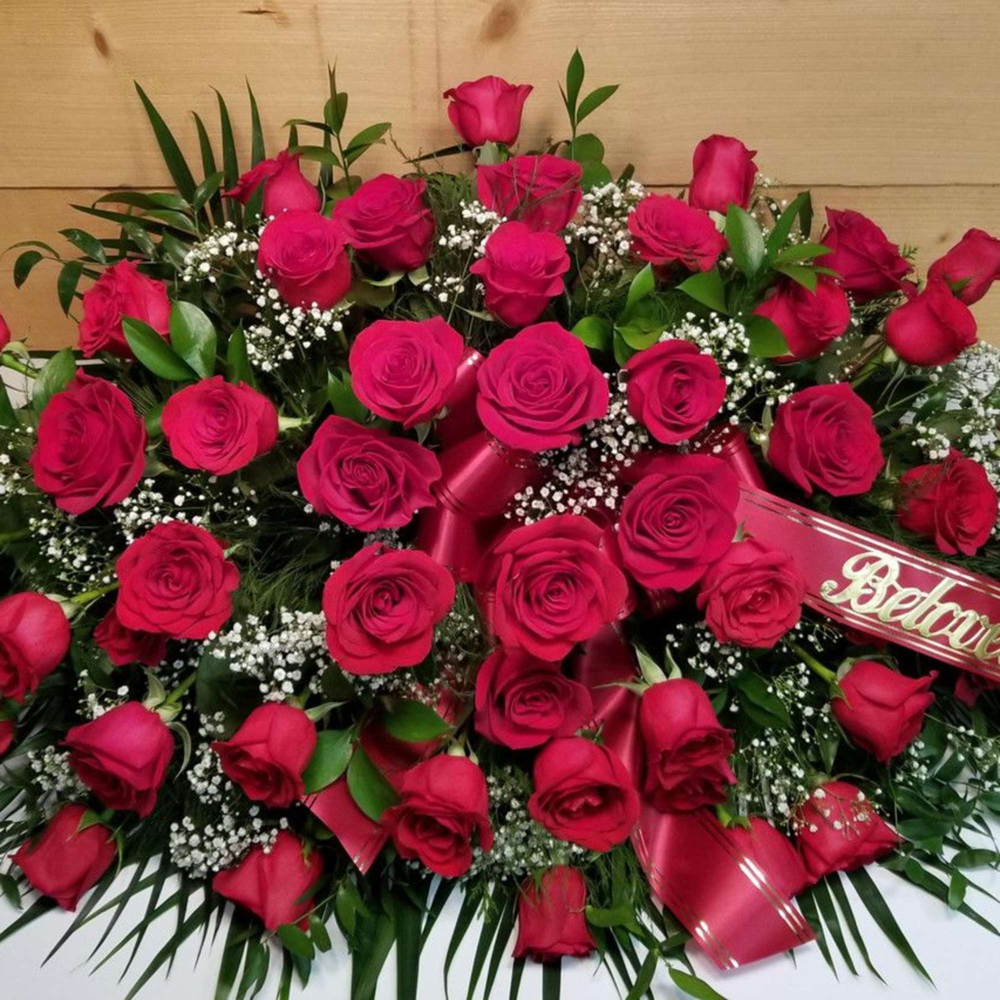 Large red rose arrangement with a ribbon reading "Beloved Husband"