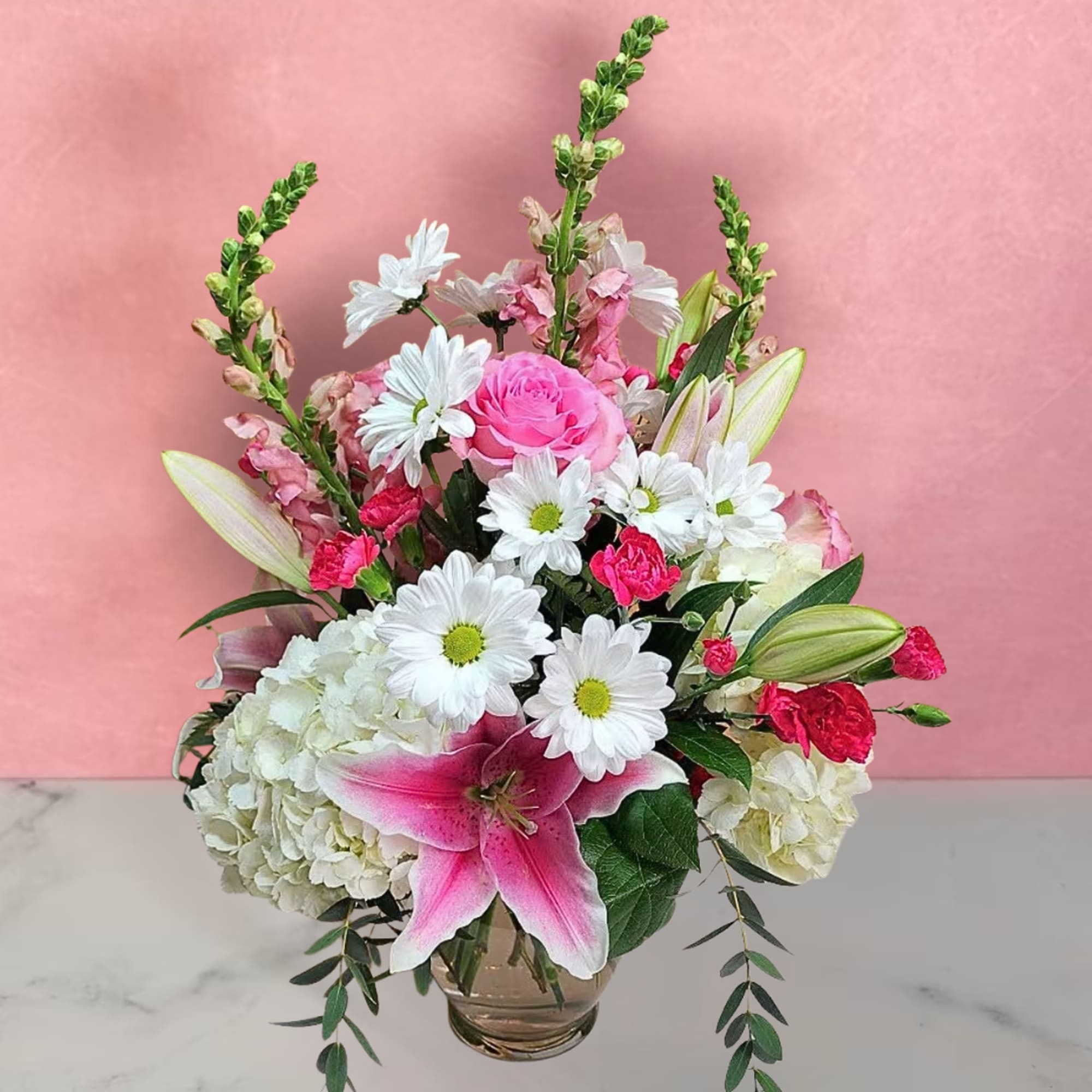 Pink and white mixed flower arrangement in a glass vase