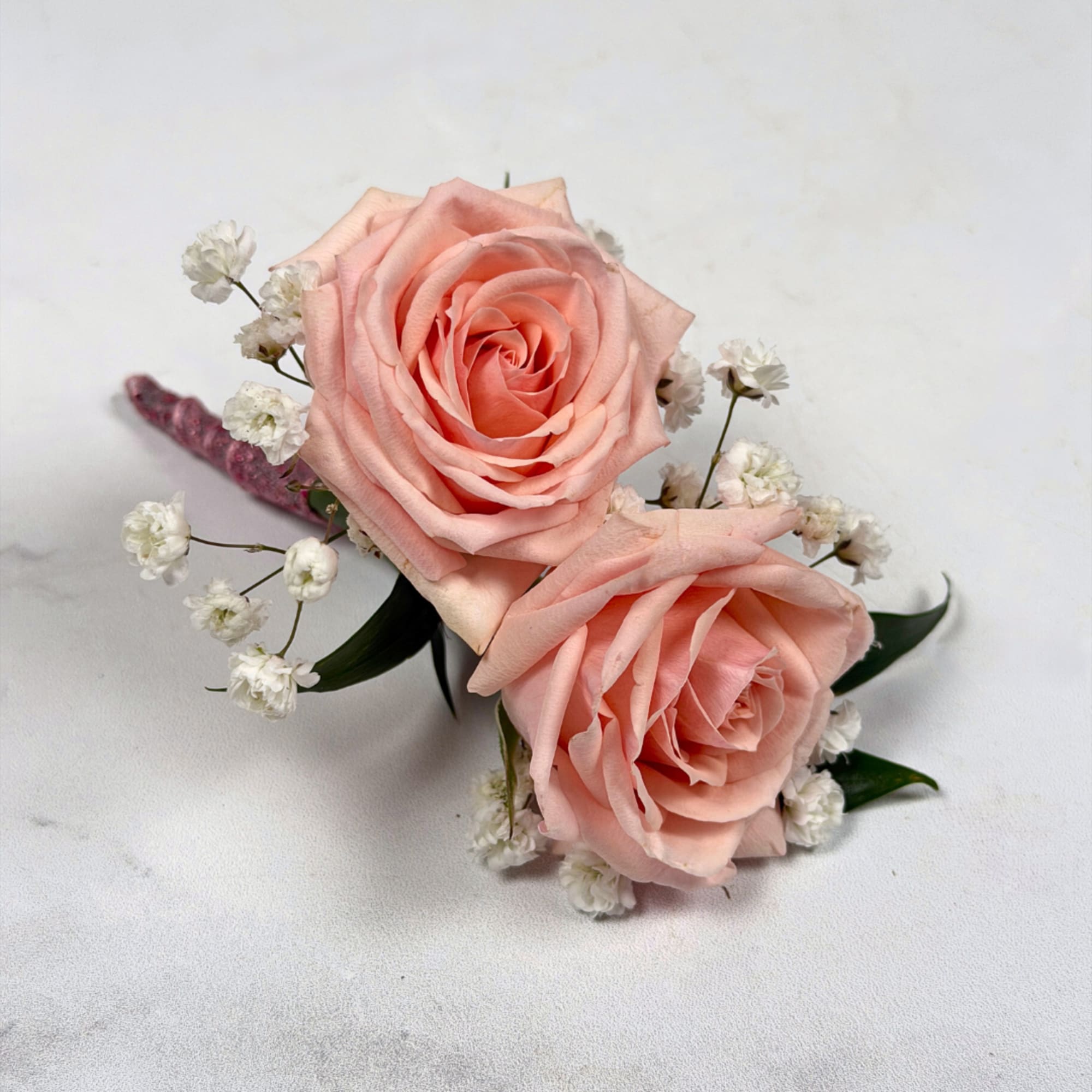 Two pale blush roses sit snugly together in this Rose Quartz boutonniere