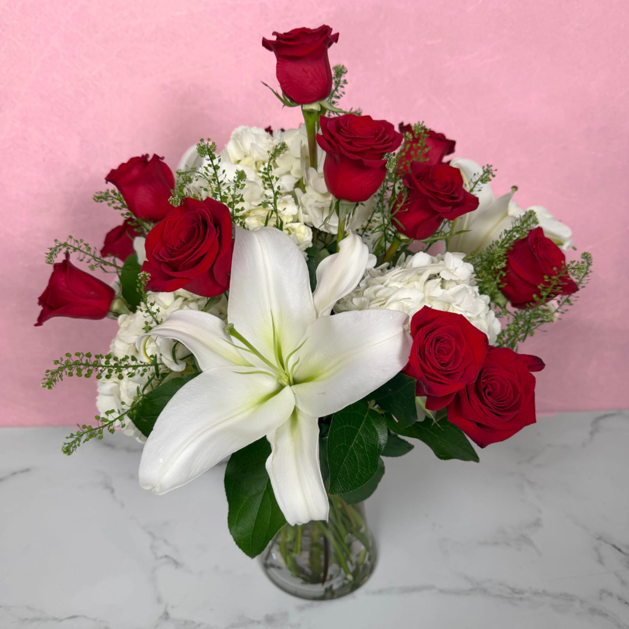 Bouquet of red roses and white lilies in a clear glass vase