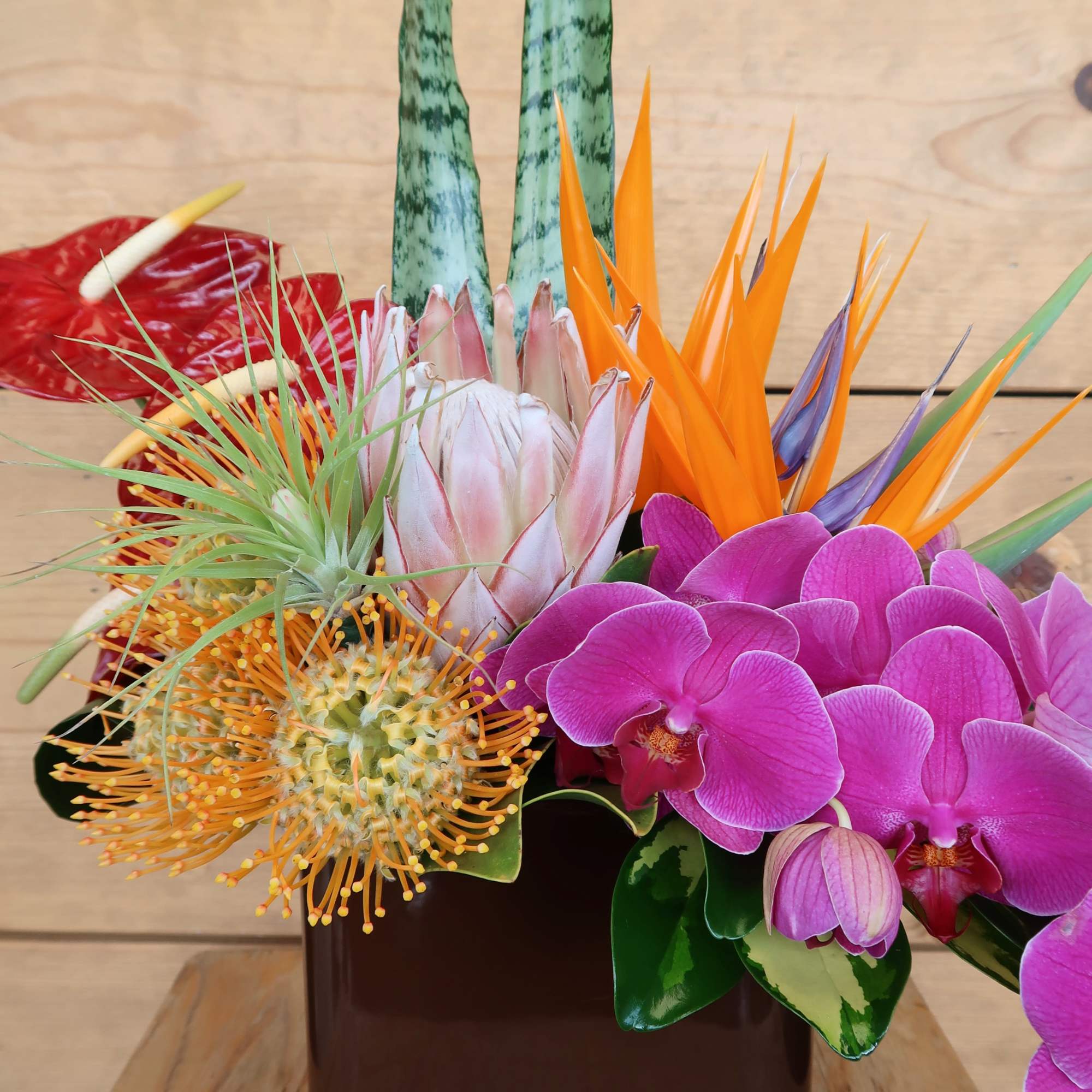 An assortment of tropical blooms in a brown ceramic vase, perfect to, photo 3 of 4