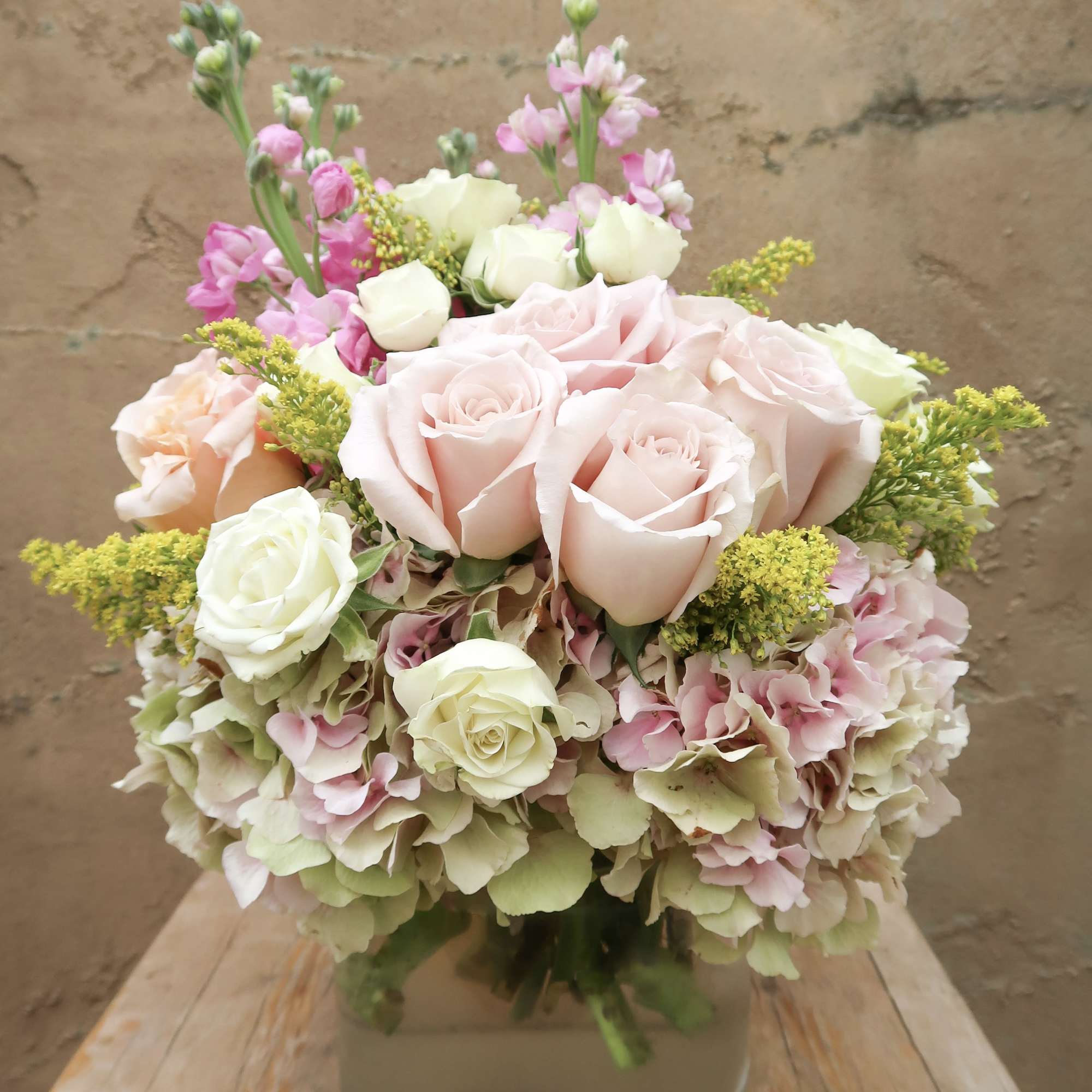 Pink and white roses with hydrangeas in a glass vase