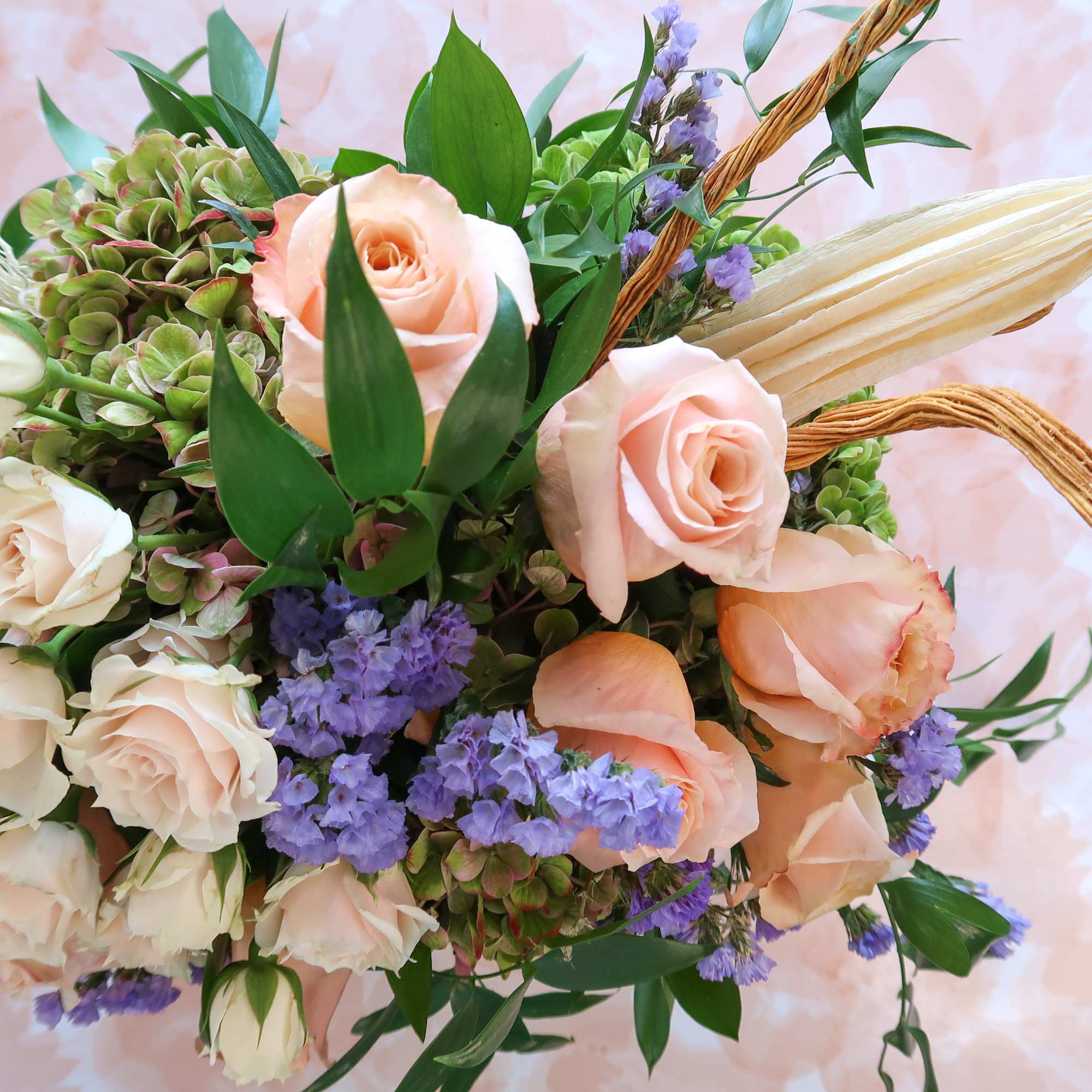 Bouquet of peach and white roses with purple filler flowers