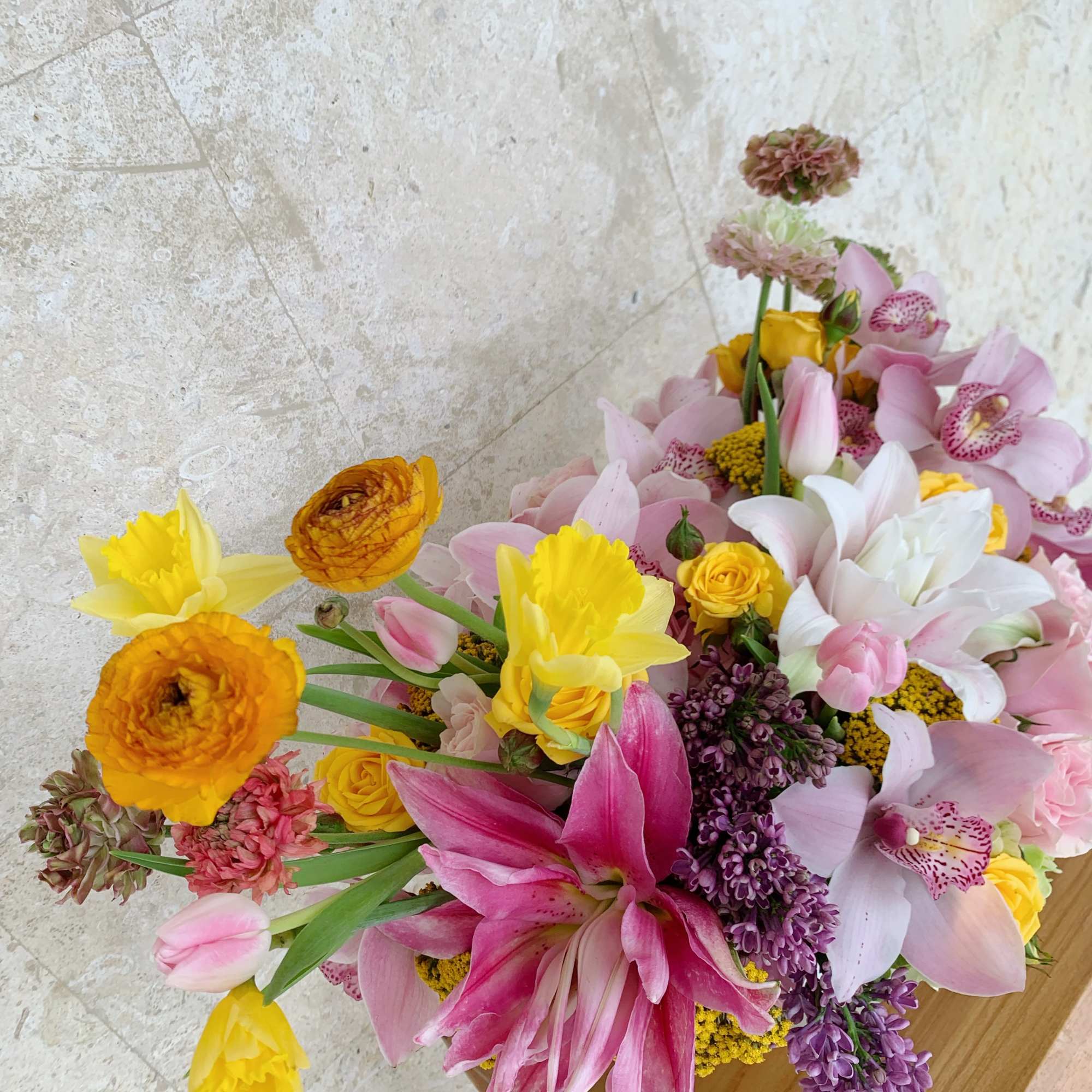 Mixed bouquet with pink lilies, yellow daffodils, and purple blooms