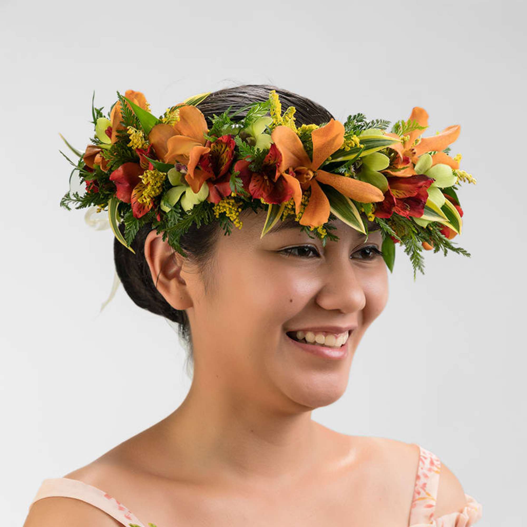 Woman wearing a tropical orange and red floral crown on her head