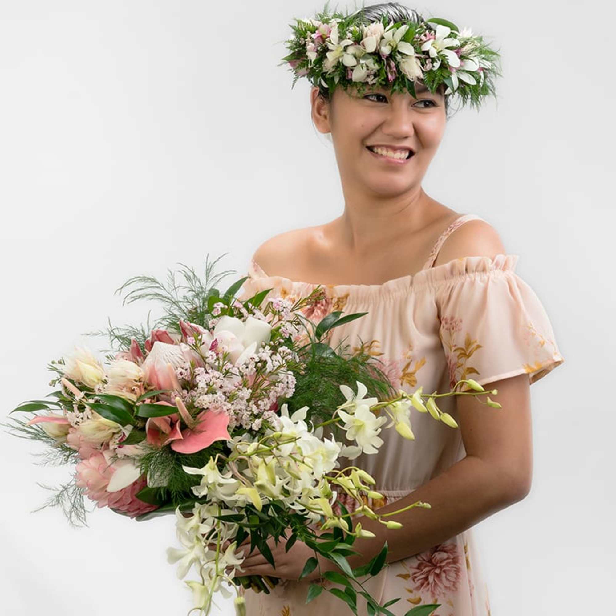 Woman wearing a floral crown and holding a large cascading bouquet of white and pink flowers