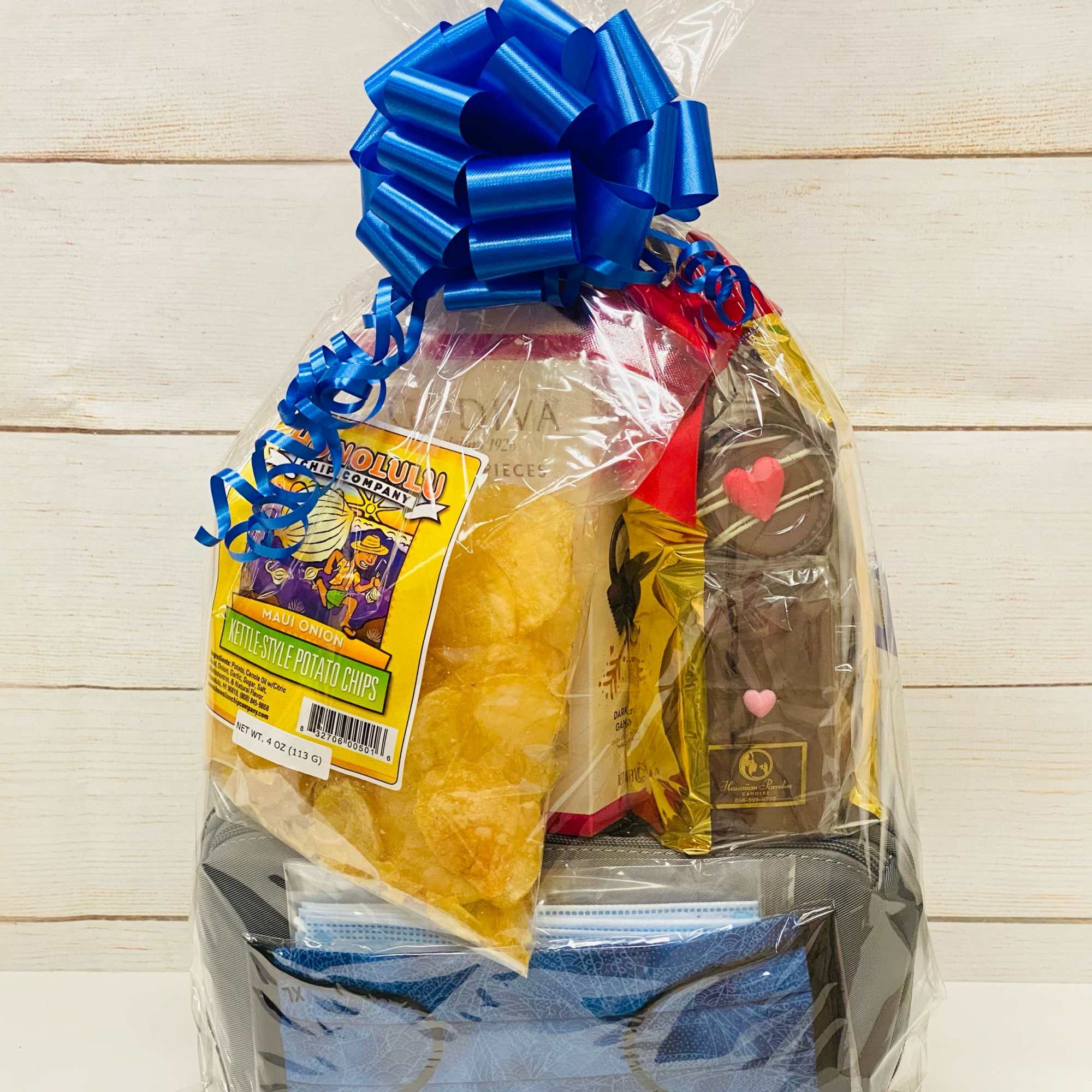 Snack gift set wrapped in clear plastic with a large blue bow on top