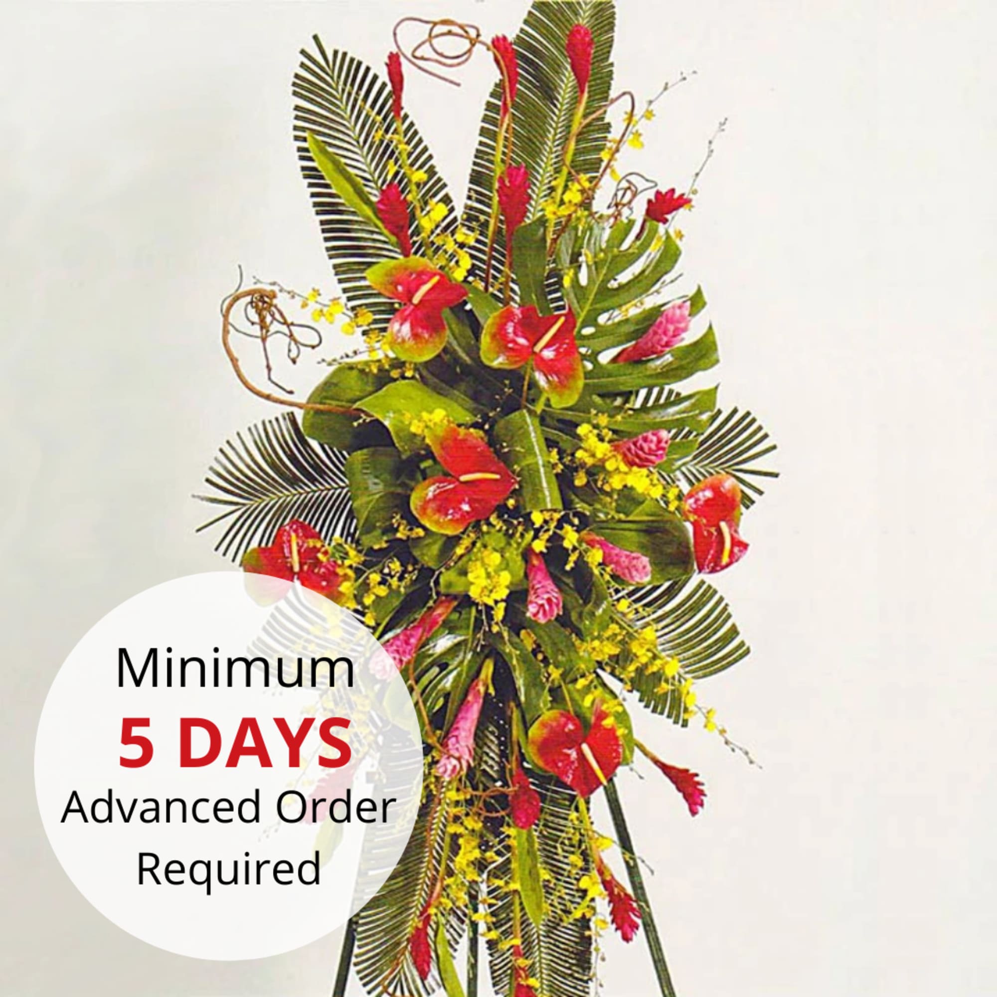 Tall tropical standing spray with red and pink flowers and yellow accents on a green leaf backdrop
