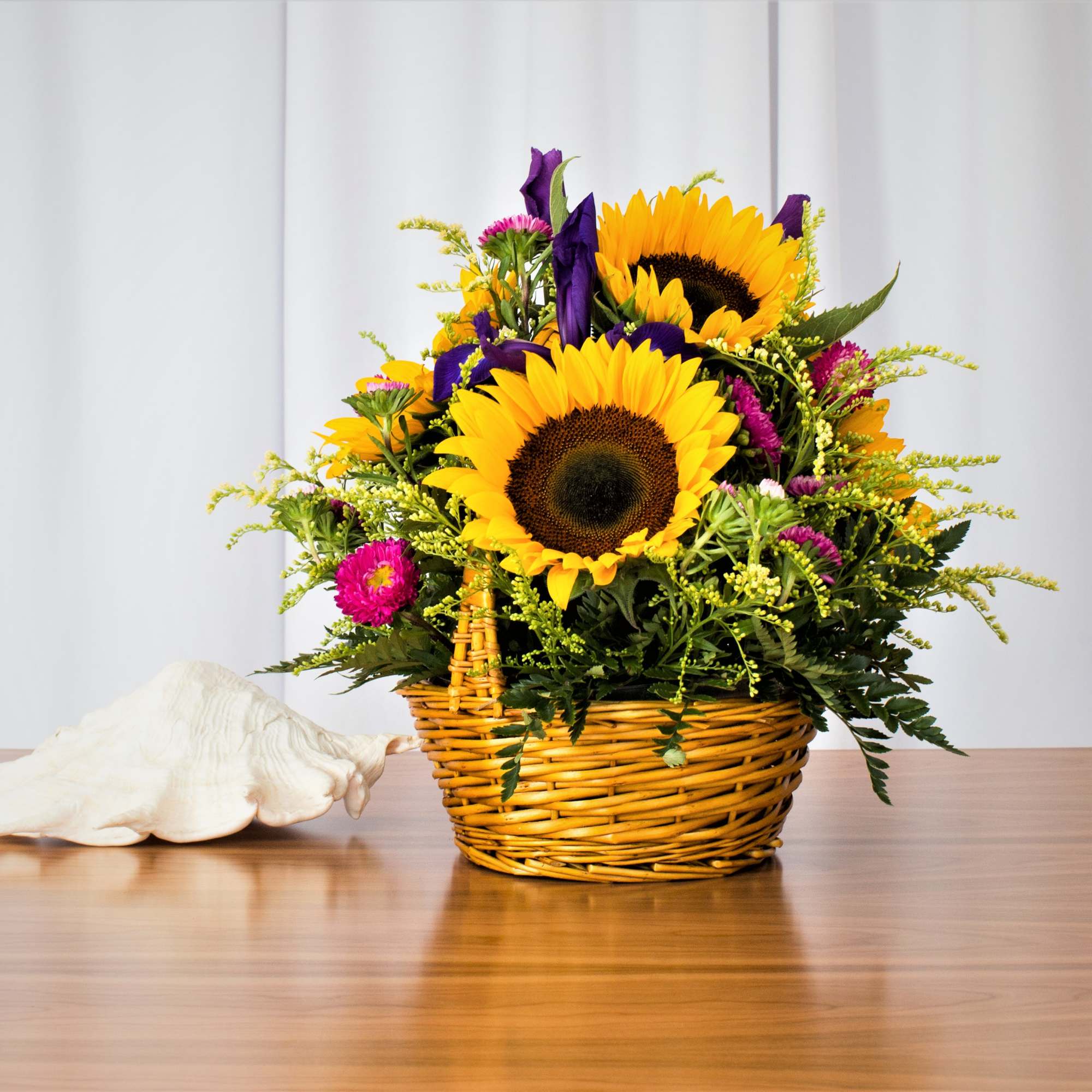 Brighten anyone's day with this delightful basket featuring sunflowers, asters, and more.